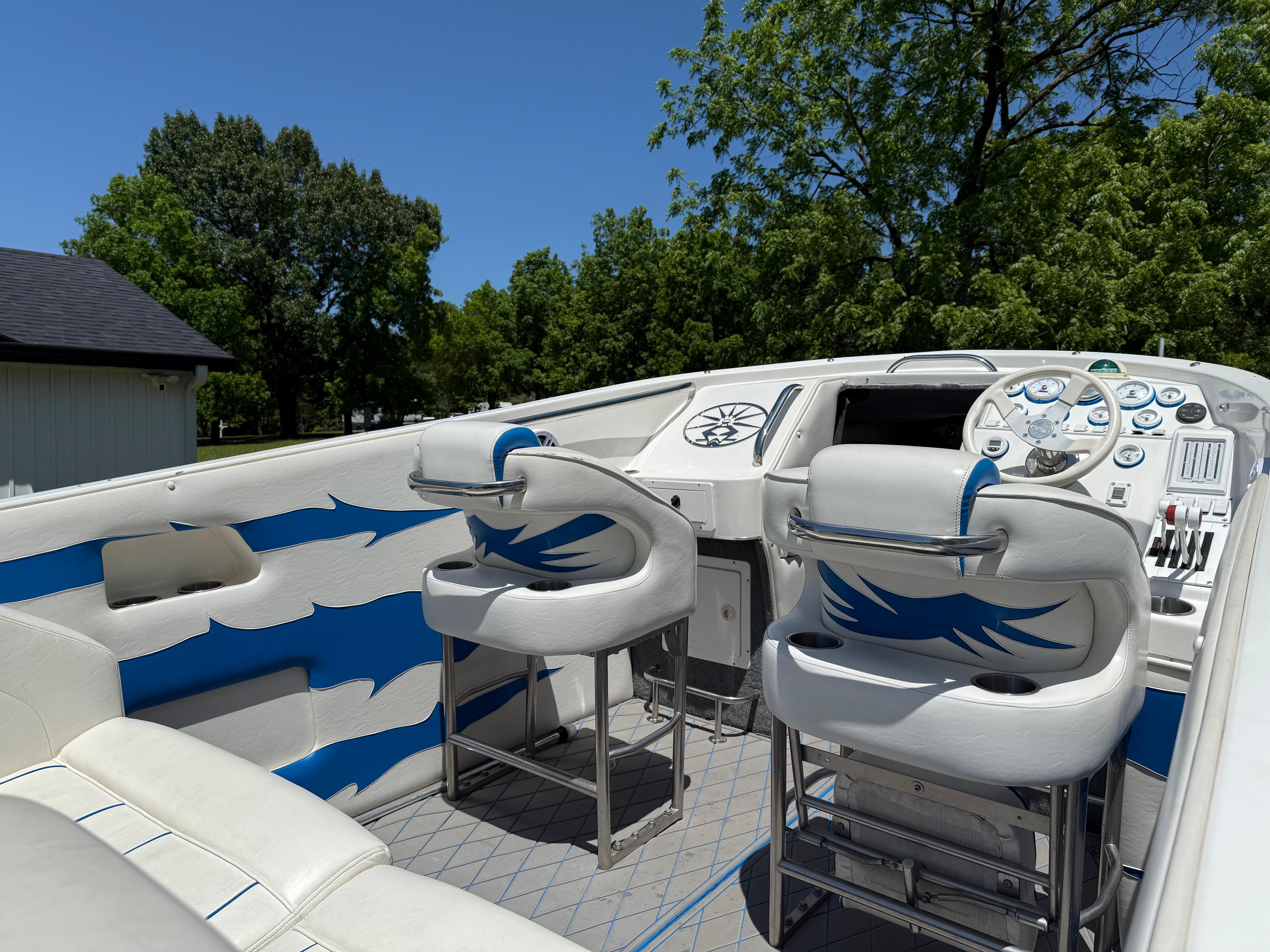 2005 Kachina Bolero boat interior with white and blue seating, dashboard, and steering wheel.