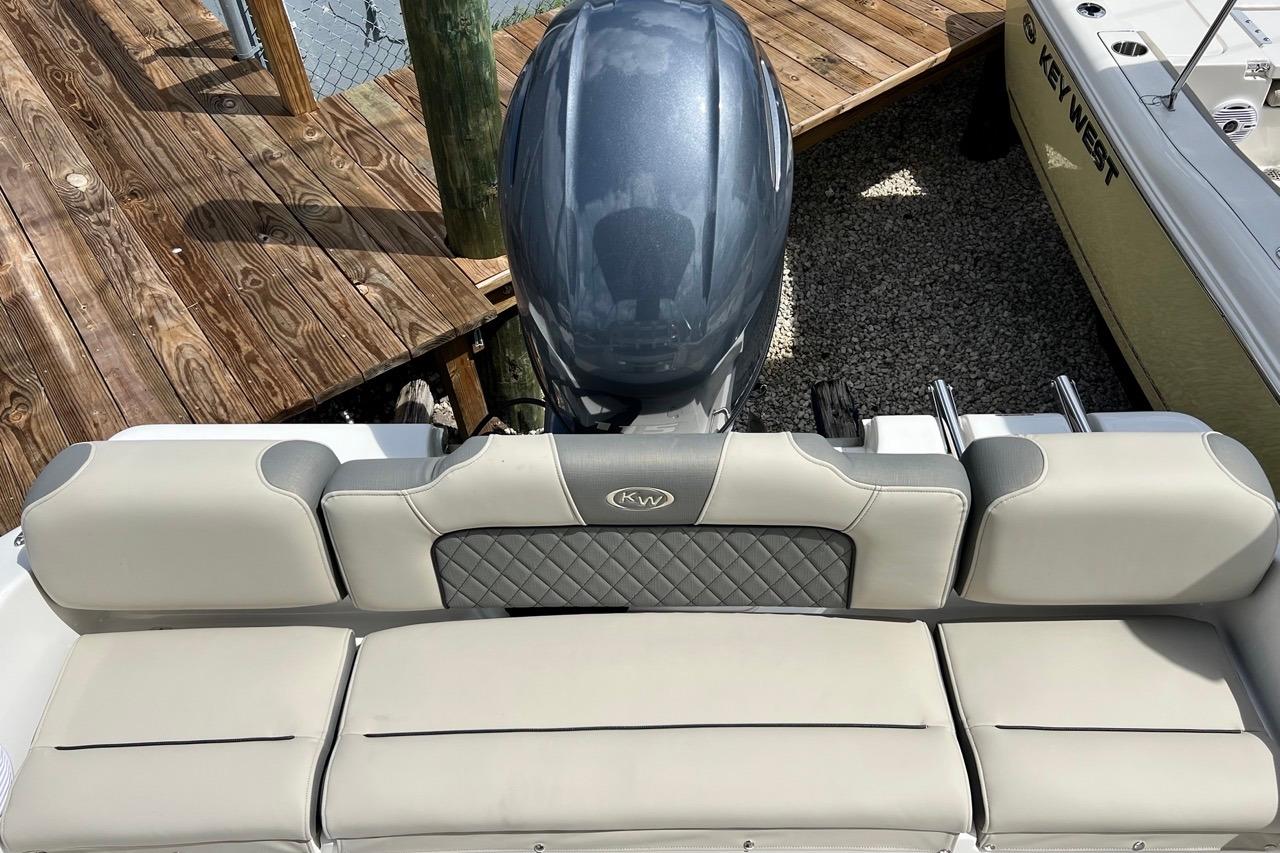 2026 Key West 189 FS boat with cushioned seating and outboard motor at dock.