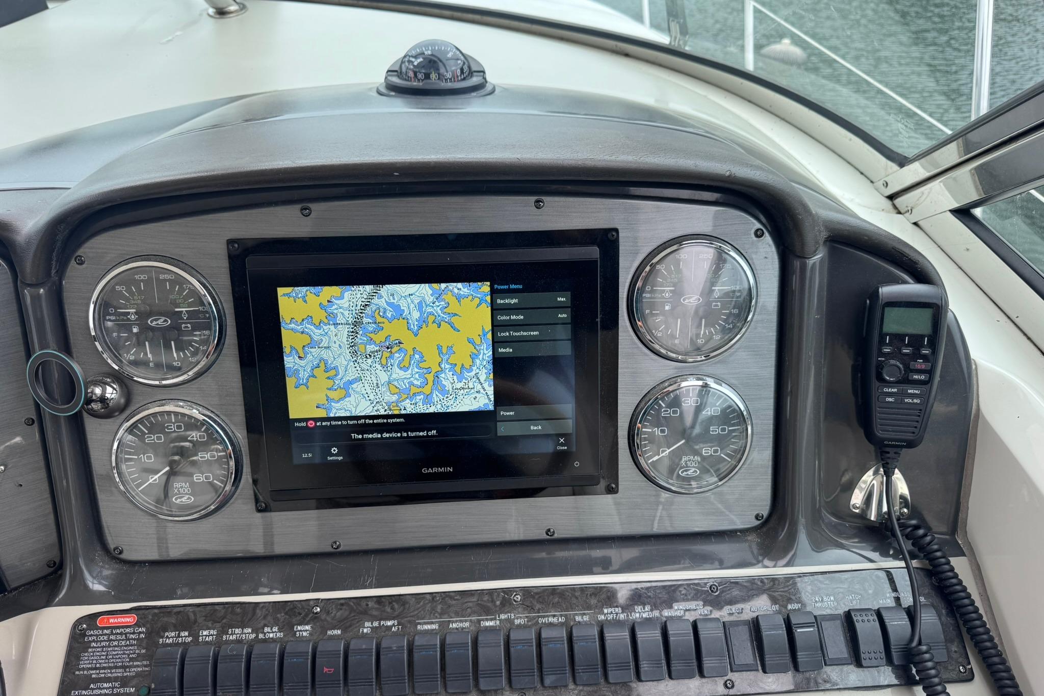 Control panel of a 2004 Sea Ray 390 Sundancer with navigation display and gauges.