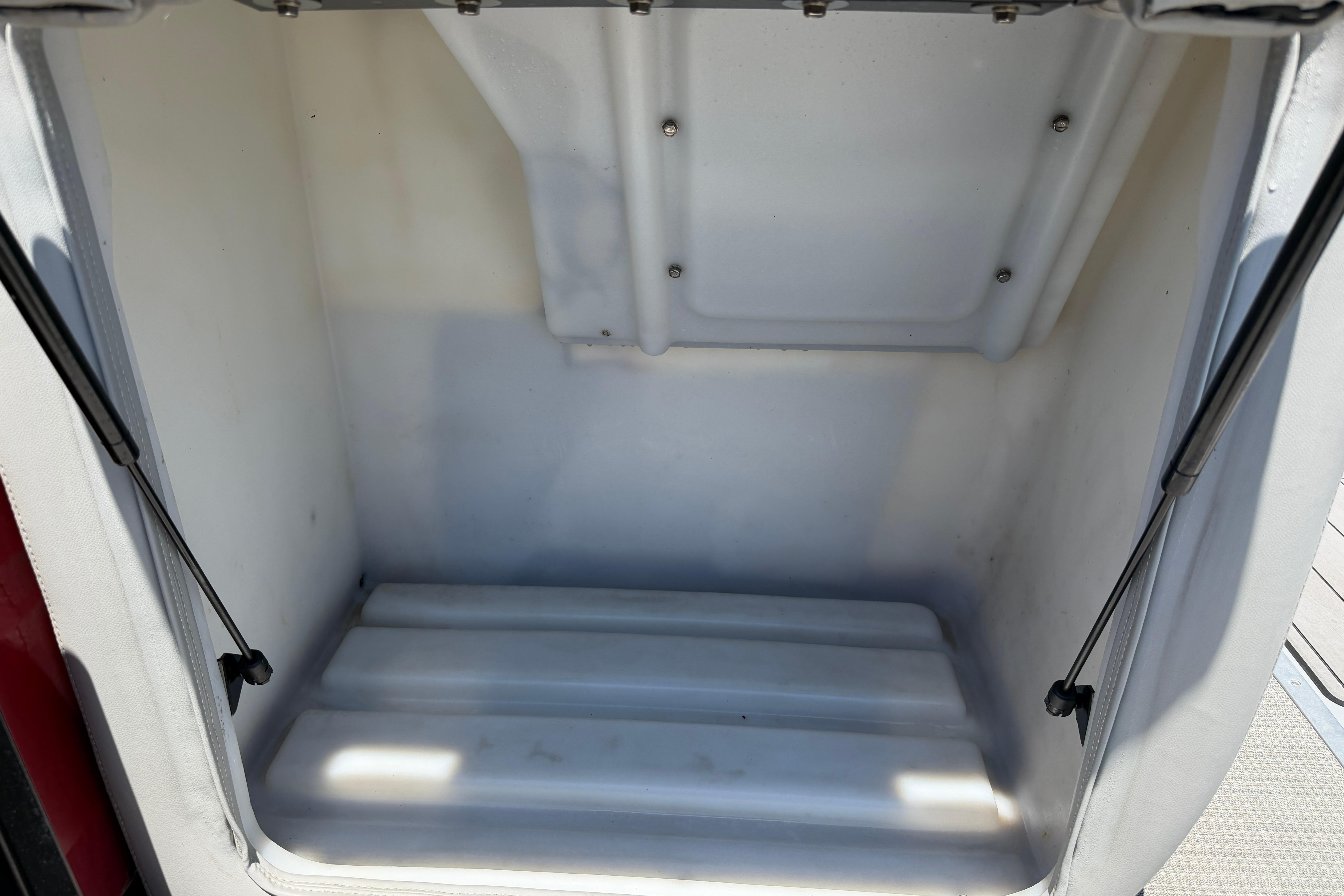 Empty storage compartment of 2024 Regency R250DL3 boat, featuring a clean, white interior.