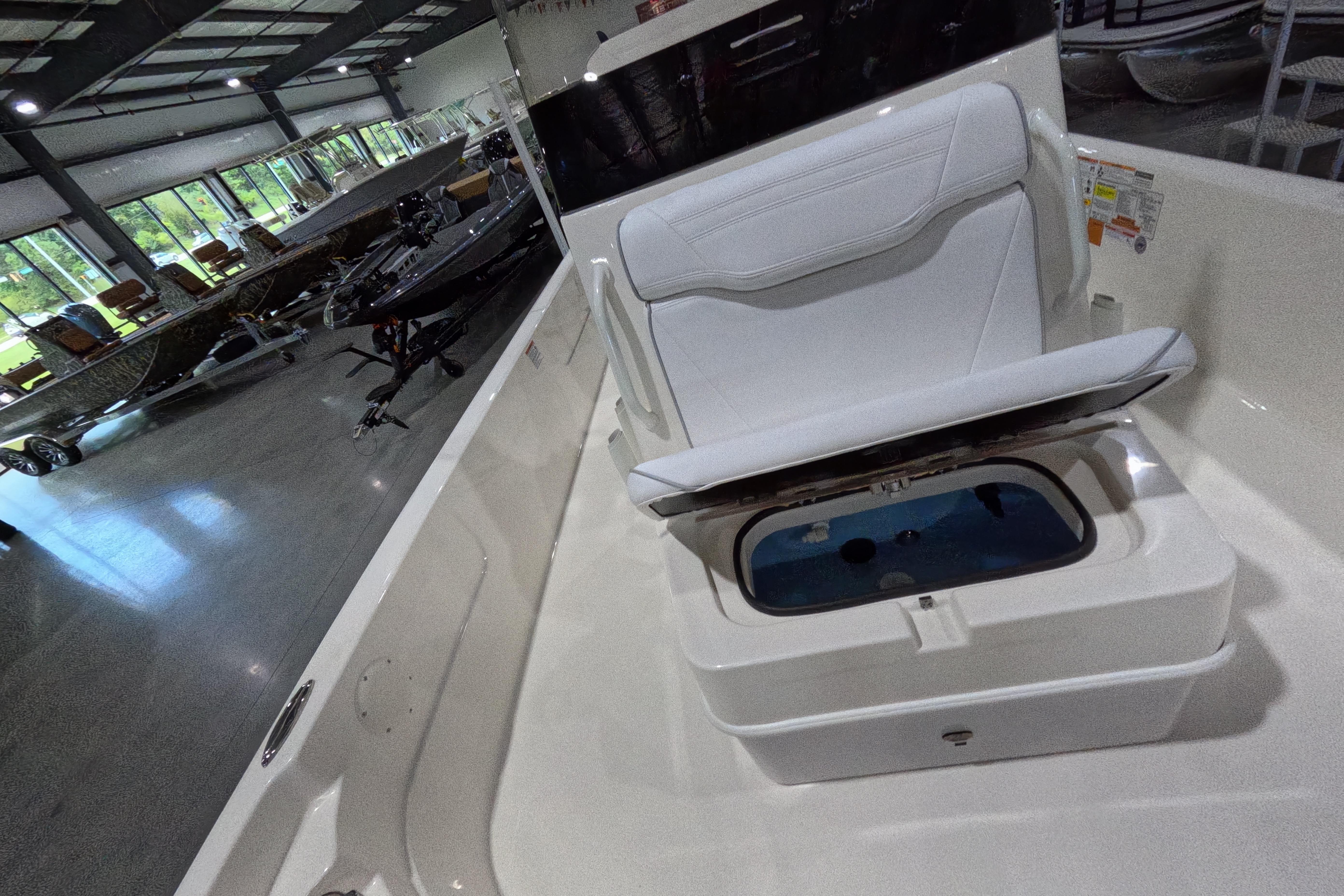 2026 Skeeter SX230 boat interior with open storage compartment in showroom.