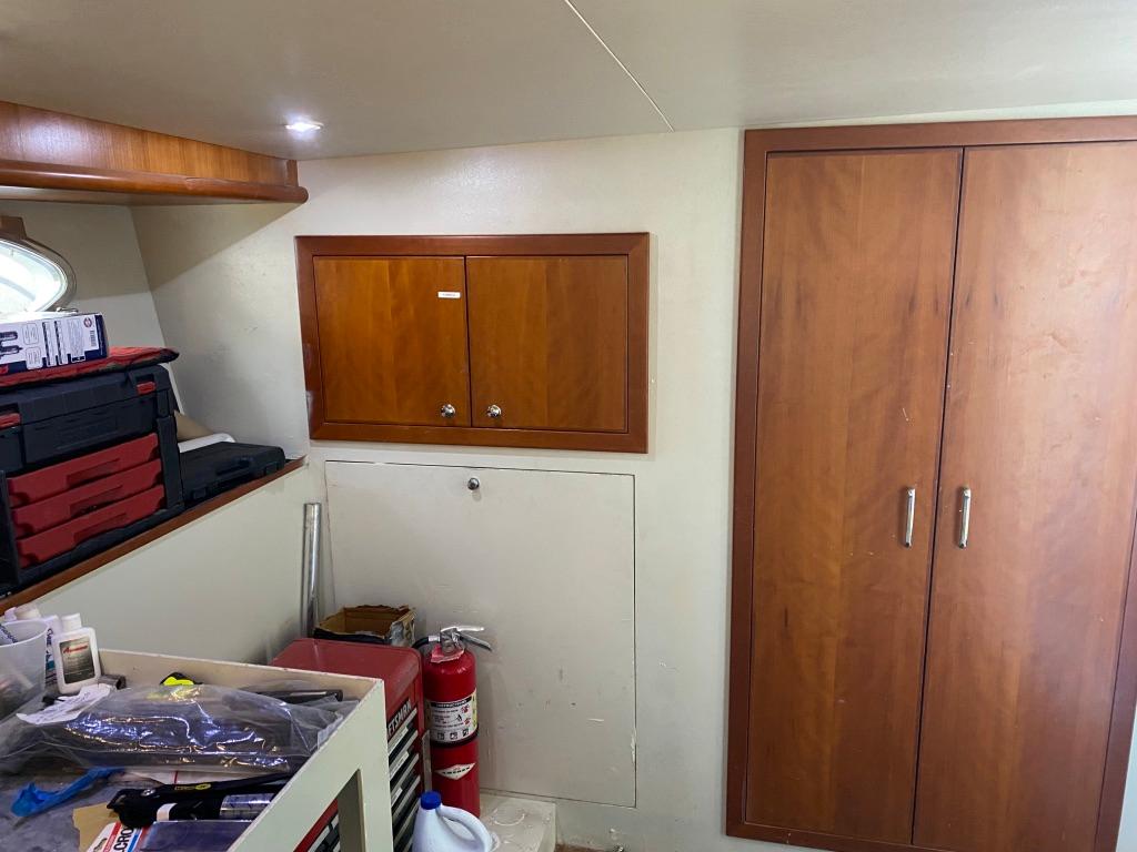 Interior of 2003 West Bay 68 yacht with wooden cabinets and storage area.
