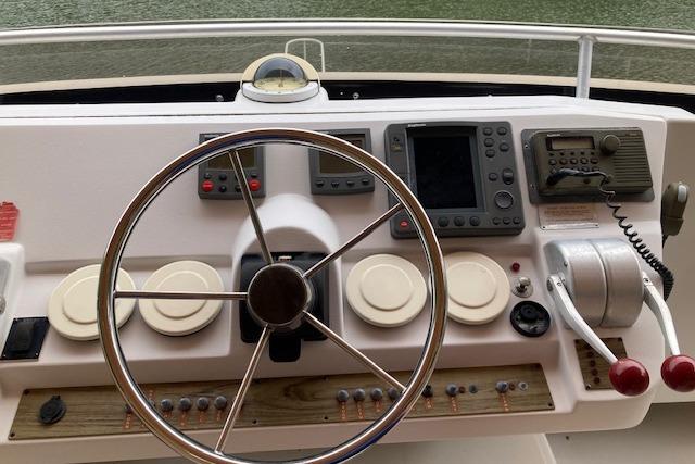Helm of 2000 Mainship 430 Trawler with steering wheel and navigation instruments.