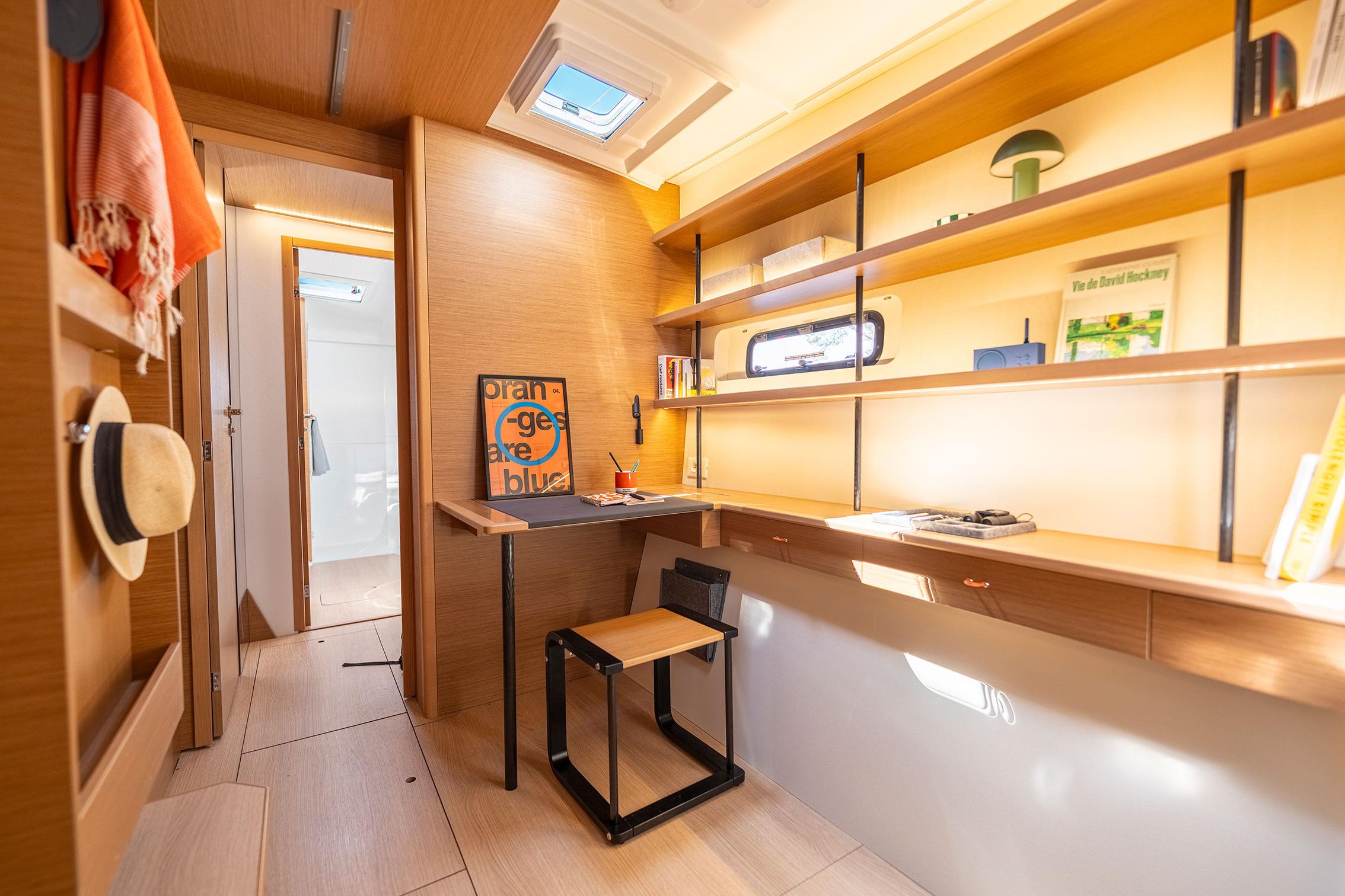 Modern interior of 2026 Excess 13 yacht with wooden shelves and desk.