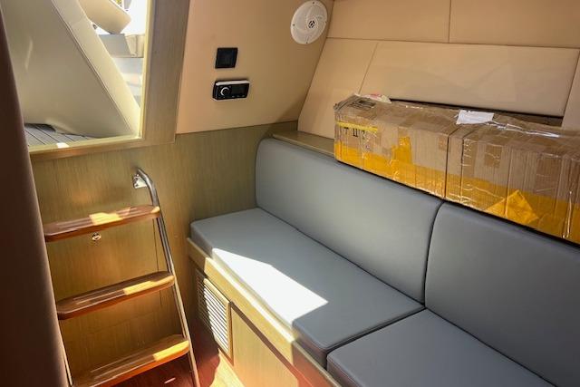 2024 Bracewell 25 interior with gray seating, wooden steps, and a cardboard box.