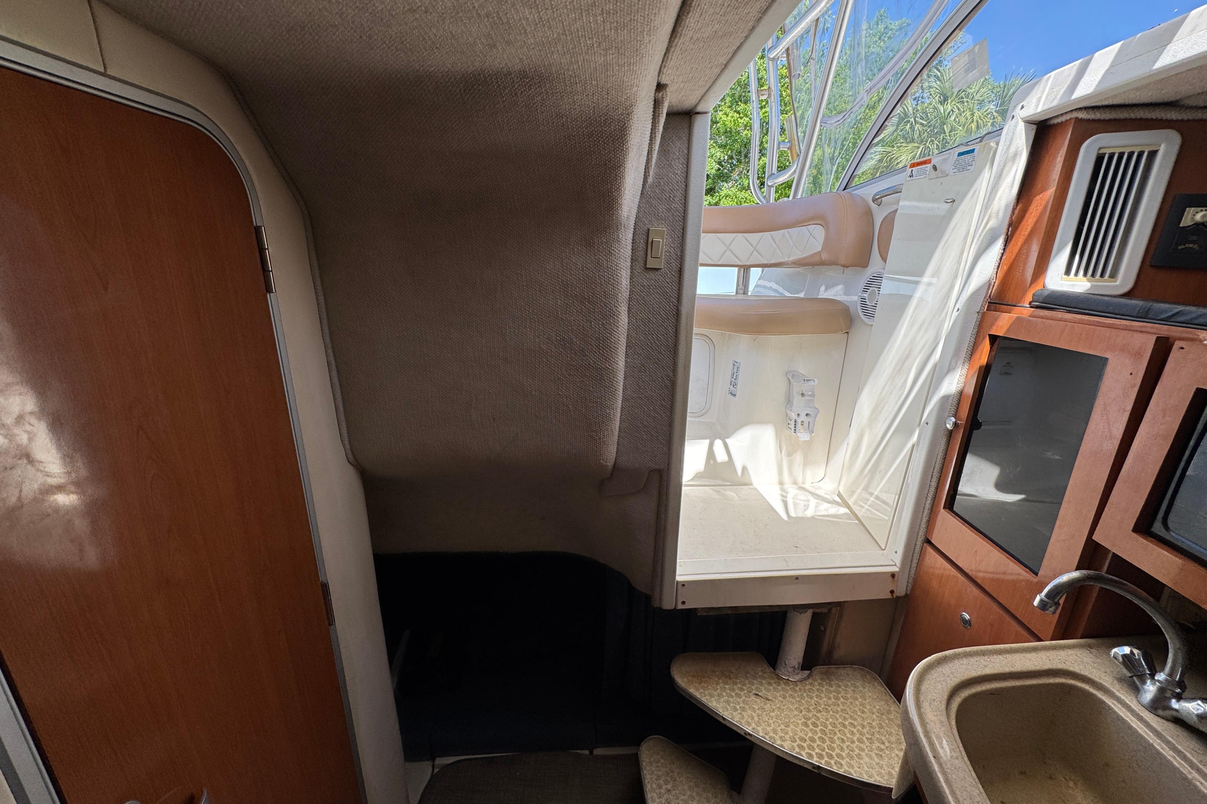 Interior view of 2004 Wellcraft 290 Coastal boat, featuring cabin stairs and kitchenette area.
