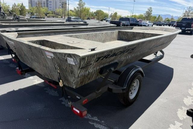 2026 Tracker Grizzly 1860 Utility boat on trailer in parking lot.