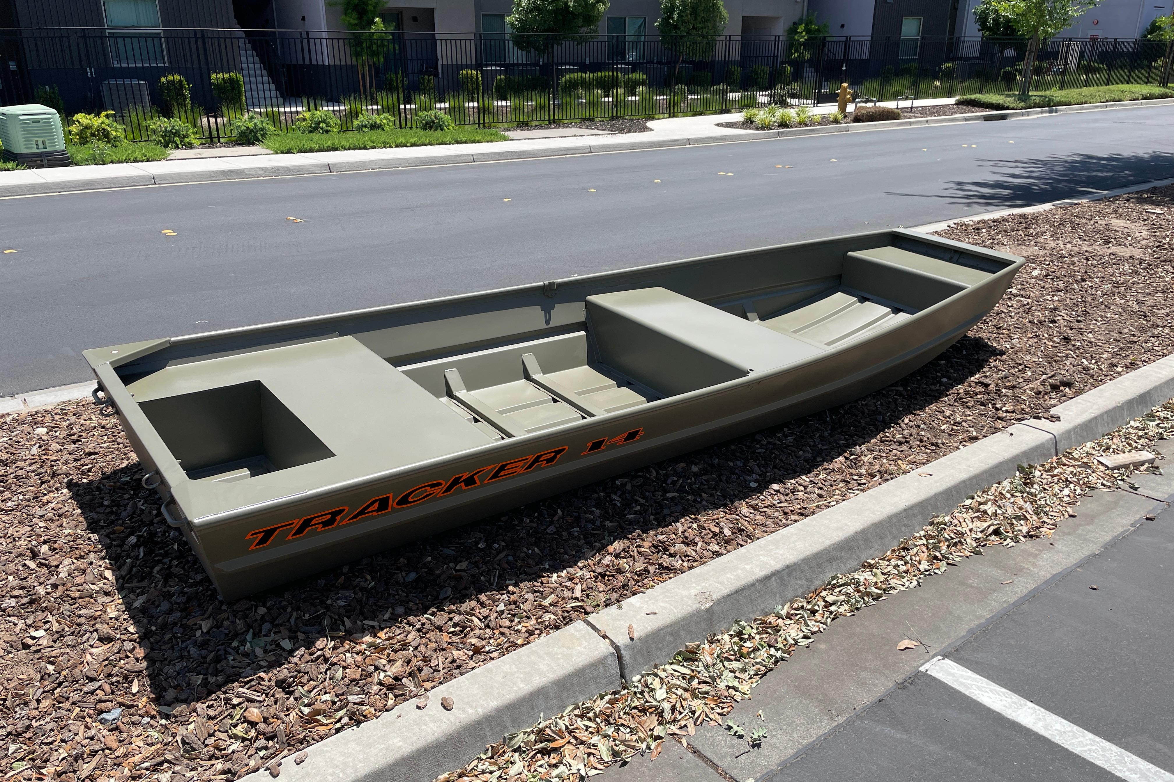 2026 Tracker Grizzly 14 Jon boat parked on roadside, showcasing its sturdy design.