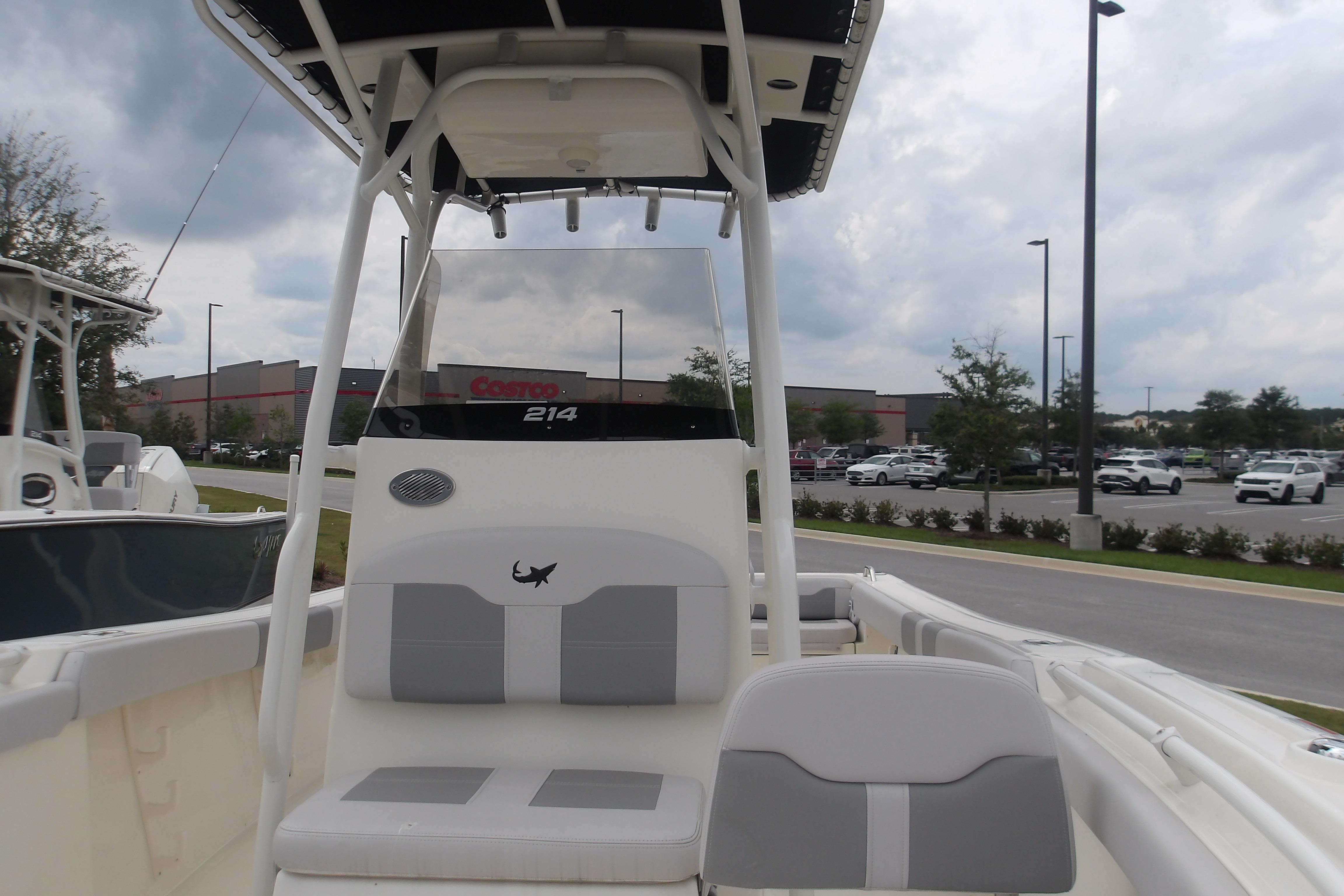 2025 Mako 214 Center Console boat in parking lot, overcast sky.