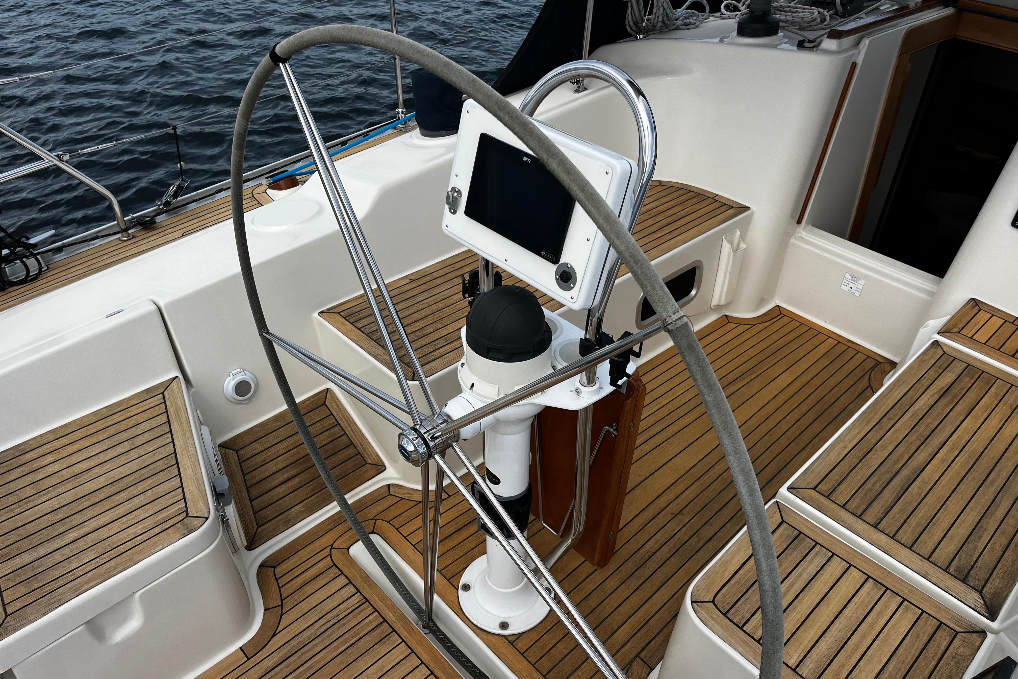 Cockpit of 2004 Hanse 411 sailboat with wooden deck and steering wheel.