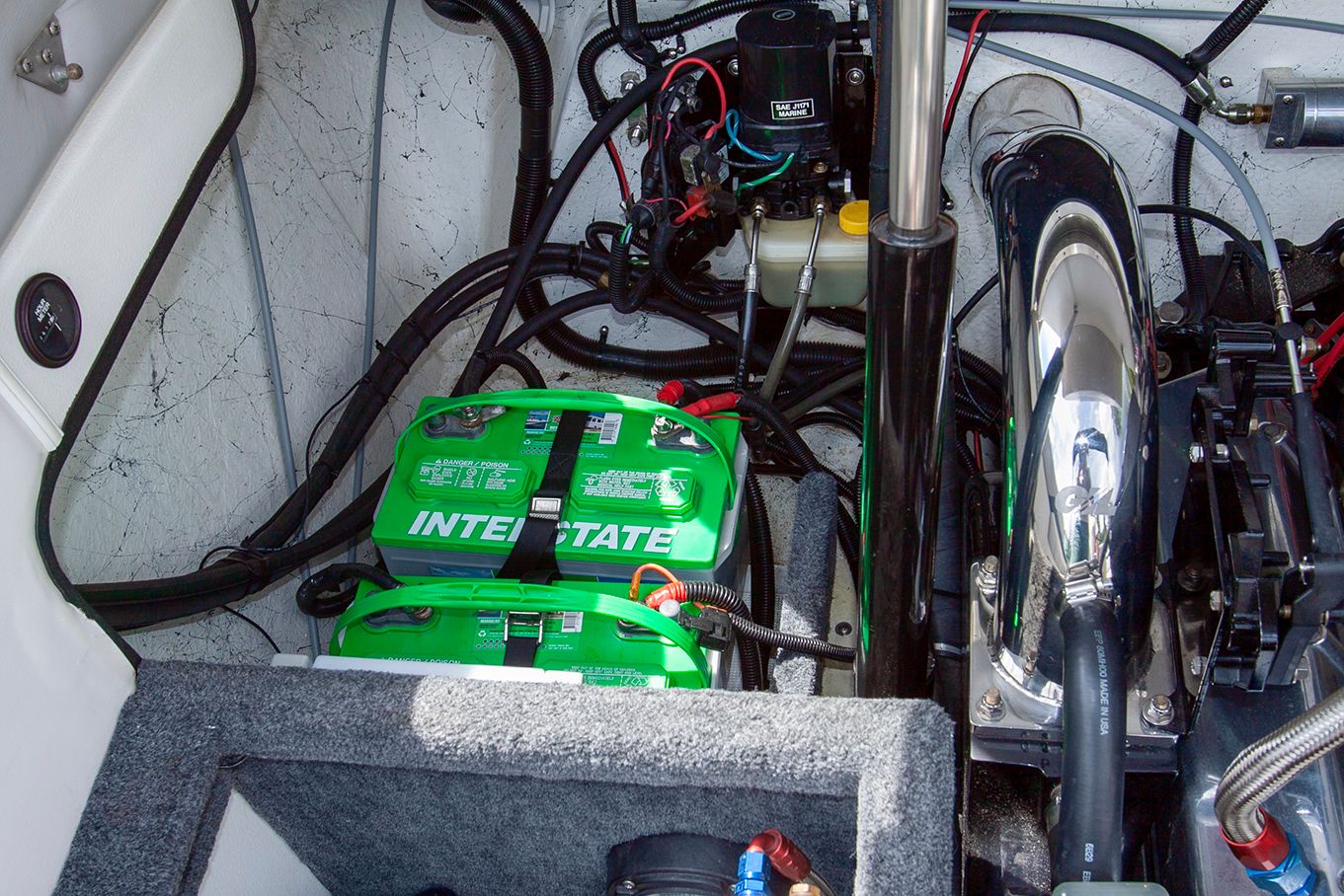 Engine compartment of a 1995 Mirage Trovare 275 with car batteries.