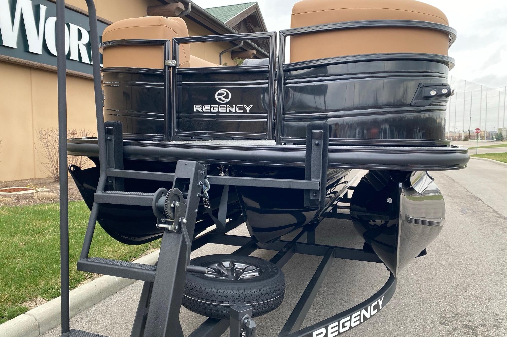 2026 Regency 230 DL pontoon boat on trailer, black exterior, parked outdoors.