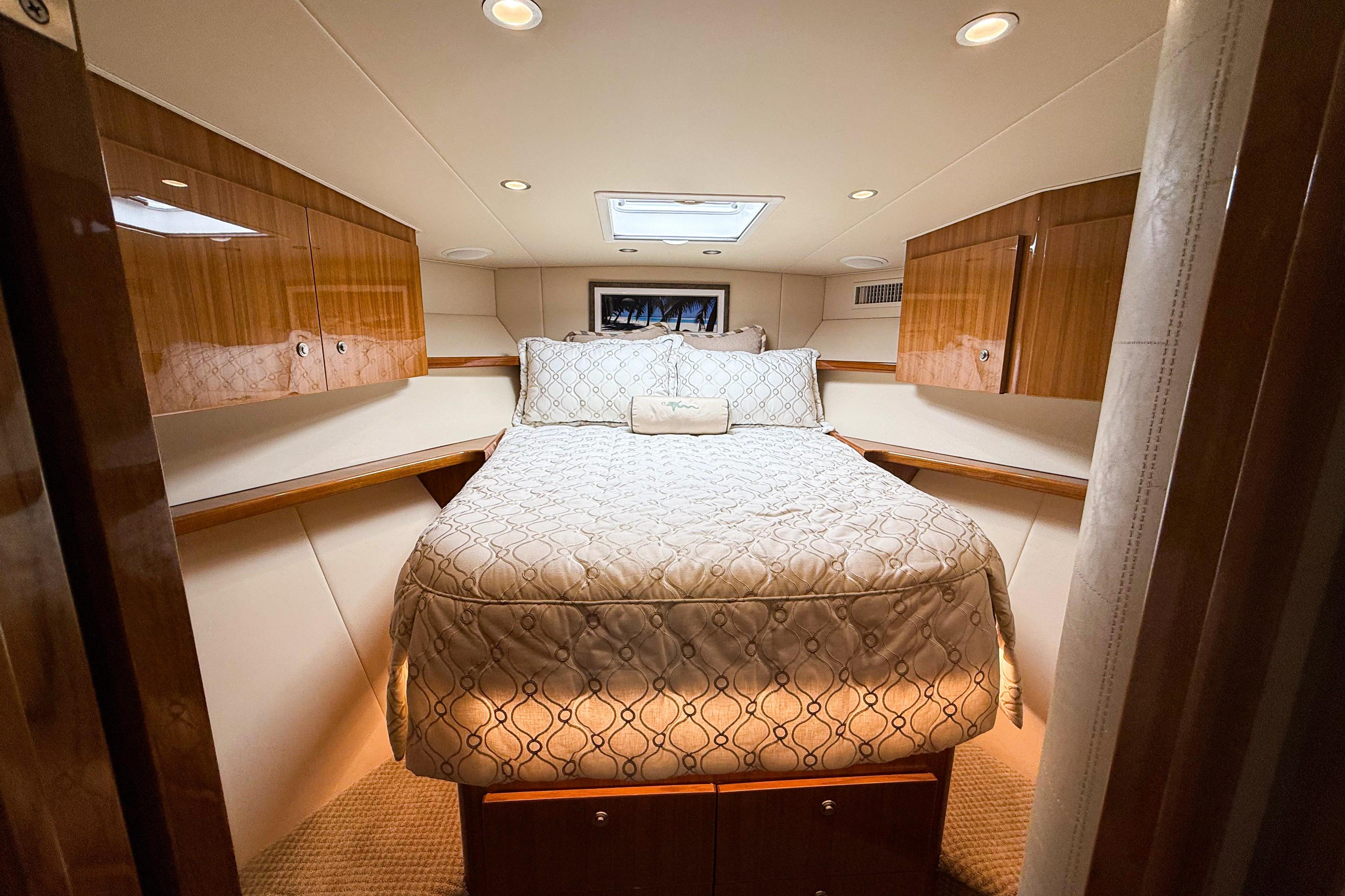 Luxurious cabin interior of 2021 Viking 44 Open yacht with elegant bedding and wood cabinetry.