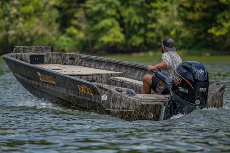 2026 Excel 183 Tomahawk boat navigating a scenic lake with lush greenery.