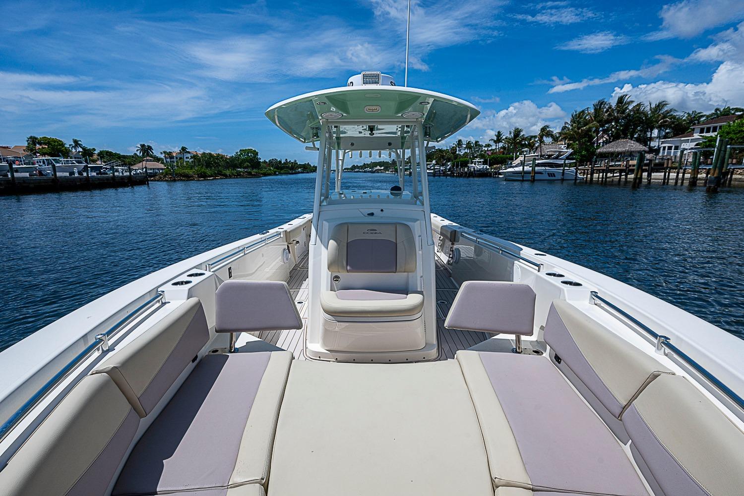 2019 Cobia 320 Center Console boat on calm water, featuring spacious seating and clear skies.