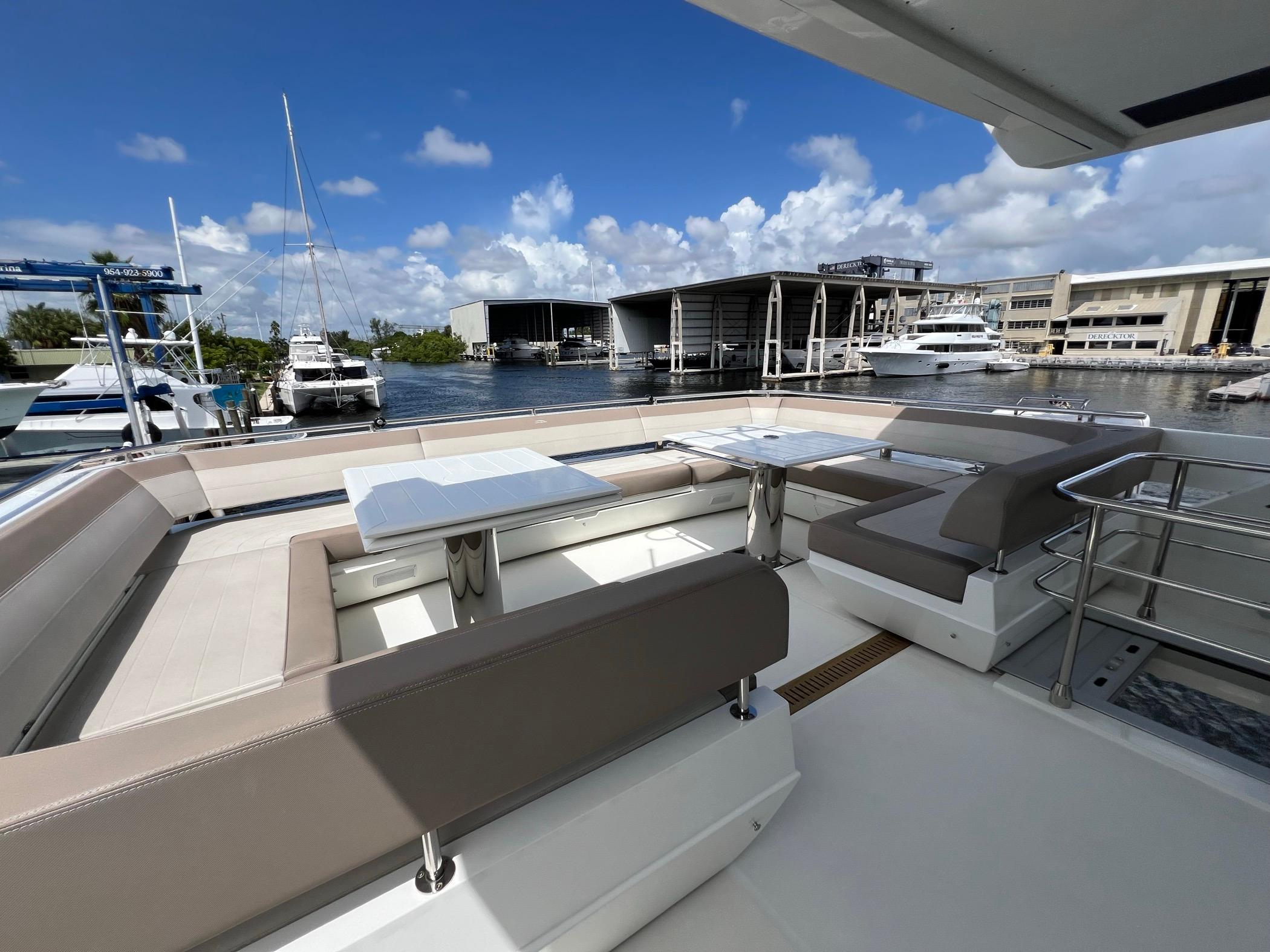 Luxurious seating area on 2020 Galeon 680 Fly yacht, docked at marina.