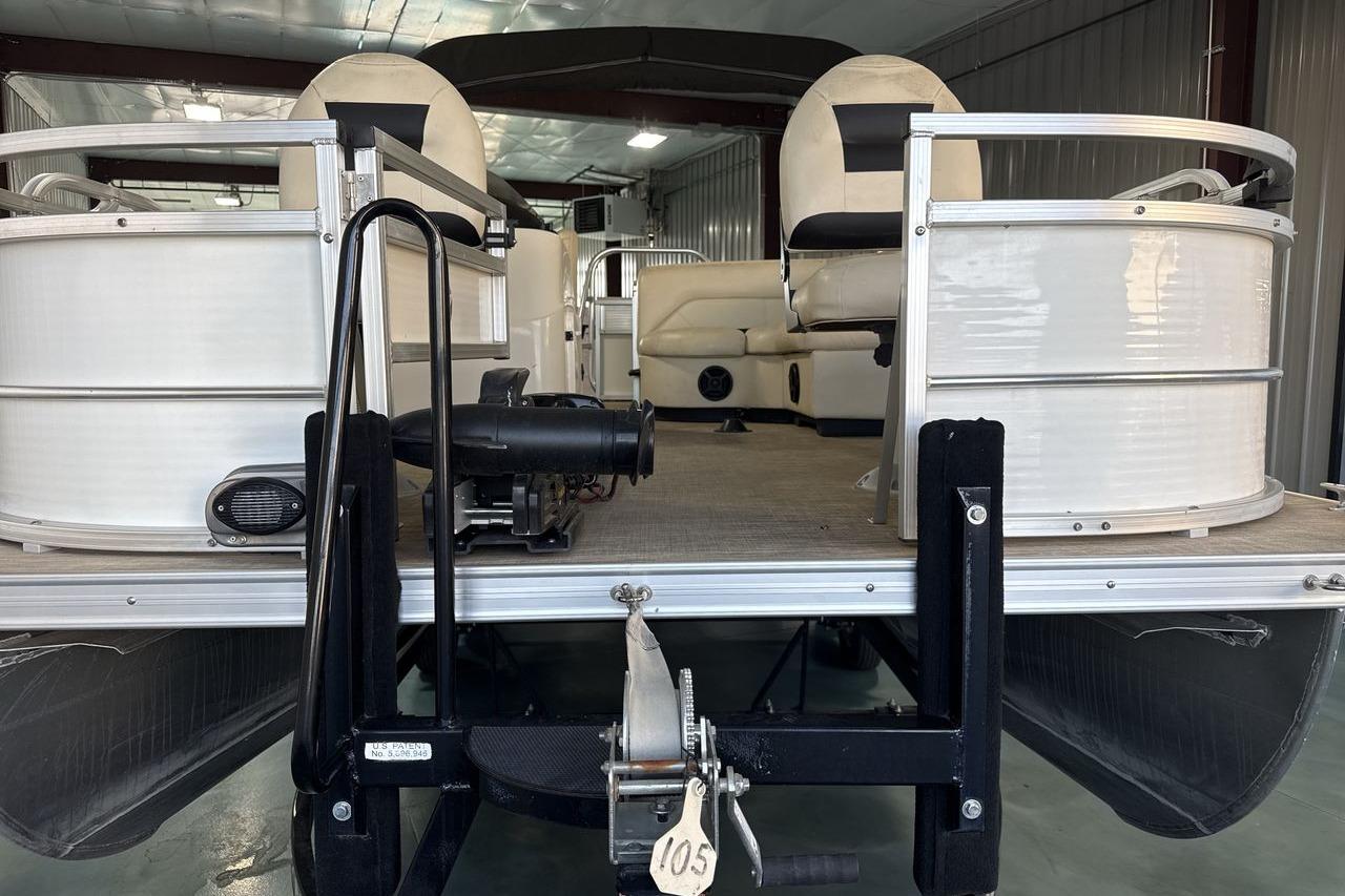 2018 Landau Alure 212 Fish pontoon boat interior with seating and railing in a storage facility.