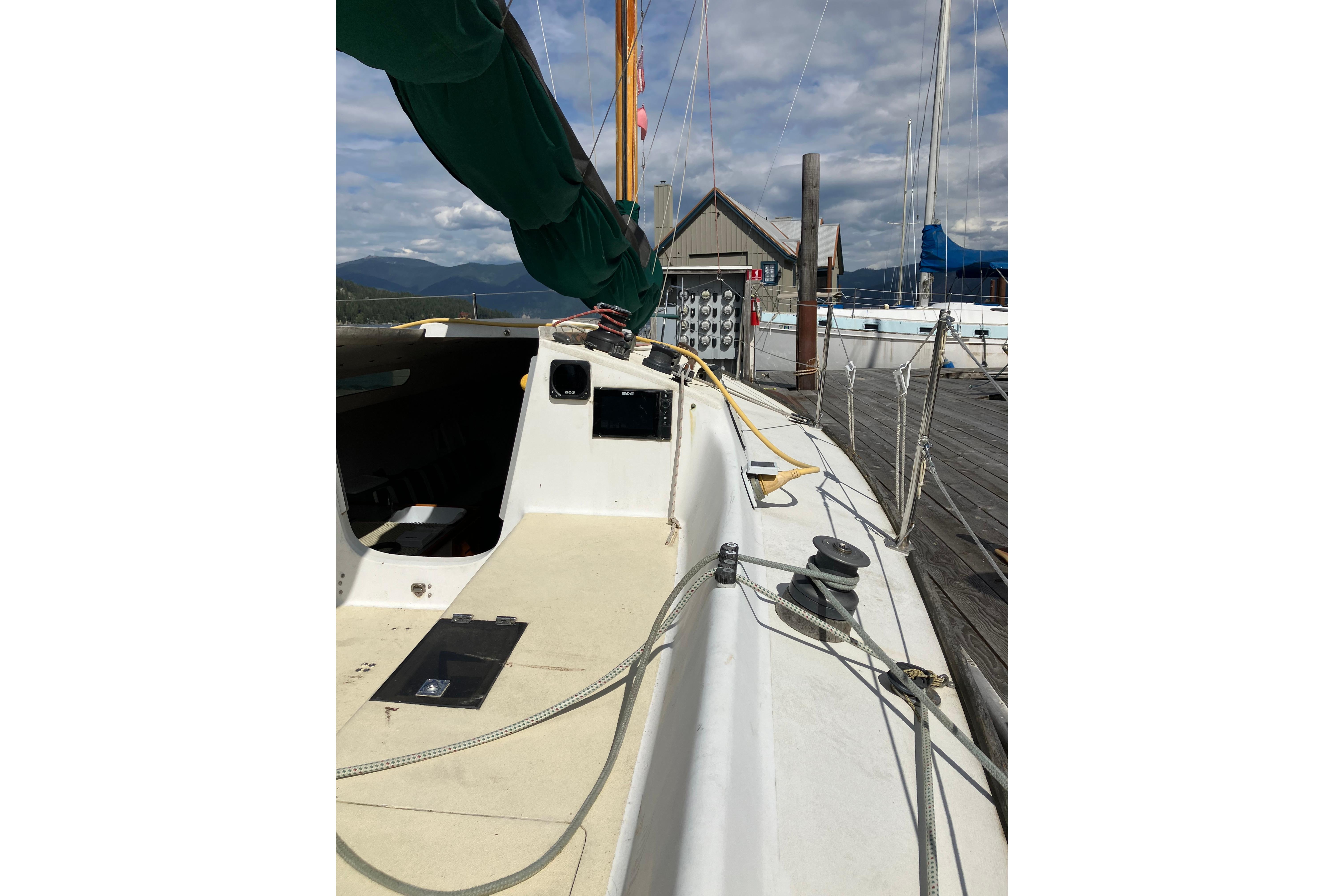 1996 Wylie 30 sailboat docked, showcasing deck and rigging under a partly cloudy sky.