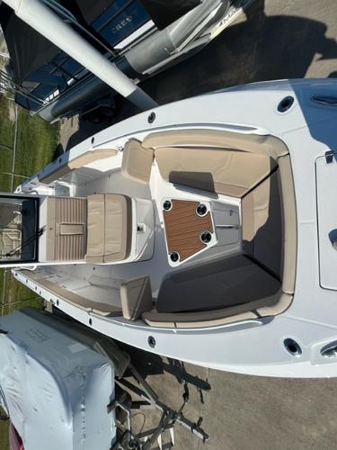 2023 Edgewater 340CC boat with beige seating and wooden table.