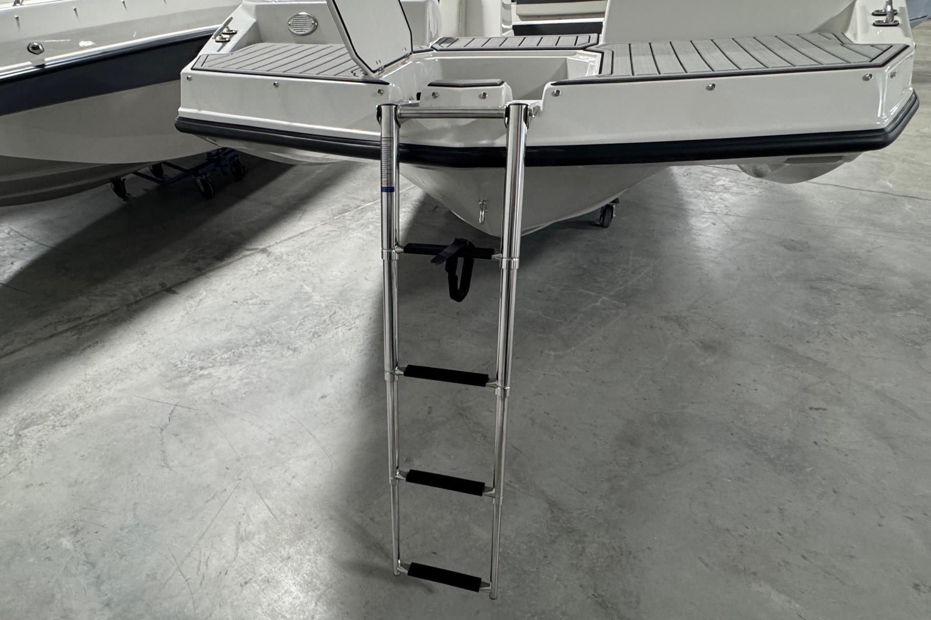 2026 Starcraft SVX 191 OB boat with extended swim ladder on concrete floor.