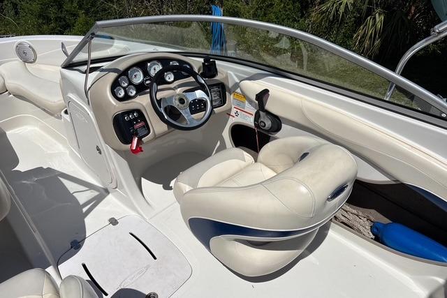 2012 Tahoe Q8 SSi boat interior with steering wheel and white seating.