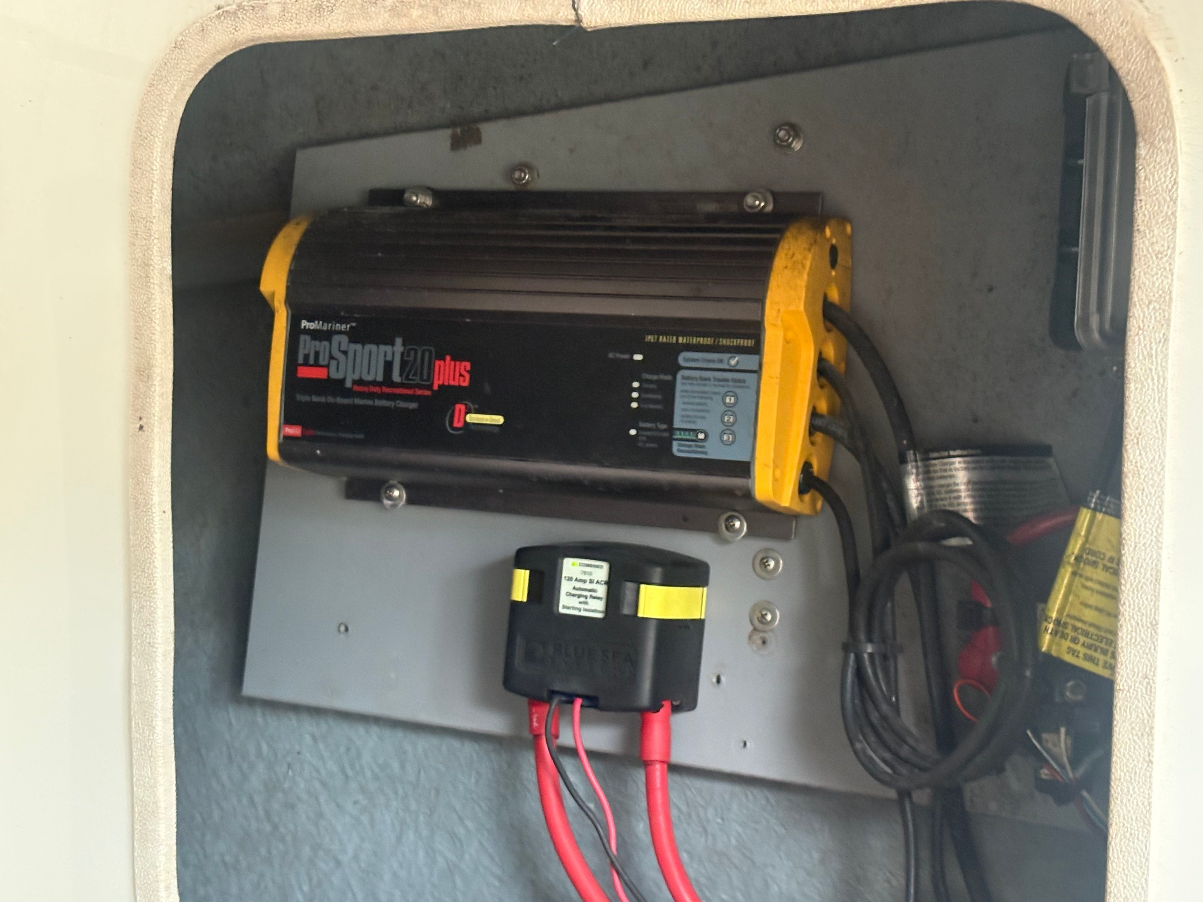 A battery charger is mounted in a compartment of the boat.