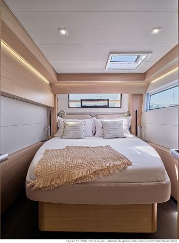 Luxurious bedroom interior of 2025 Lagoon 51 ICONIC yacht with modern design and natural lighting.