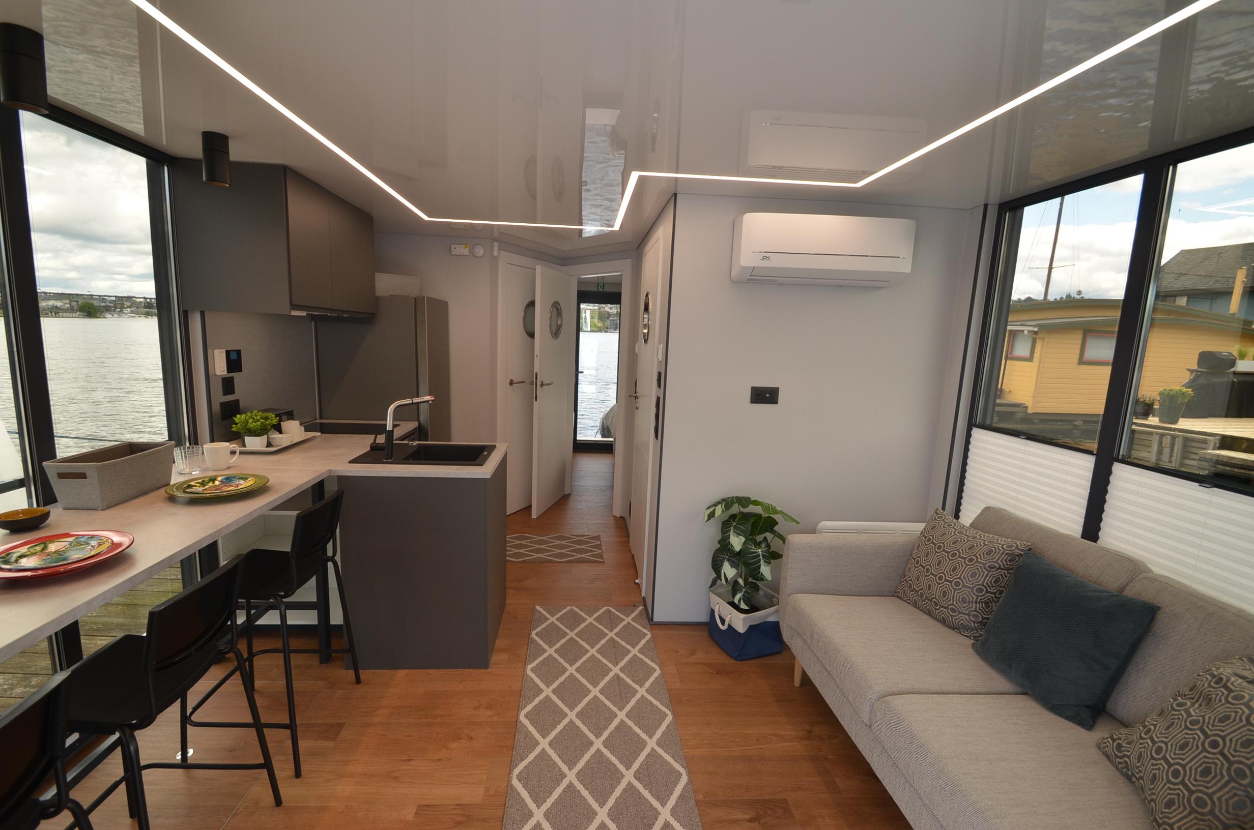 Modern La Mare 2024 houseboat interior with sleek kitchen, cozy living area, and waterfront view.