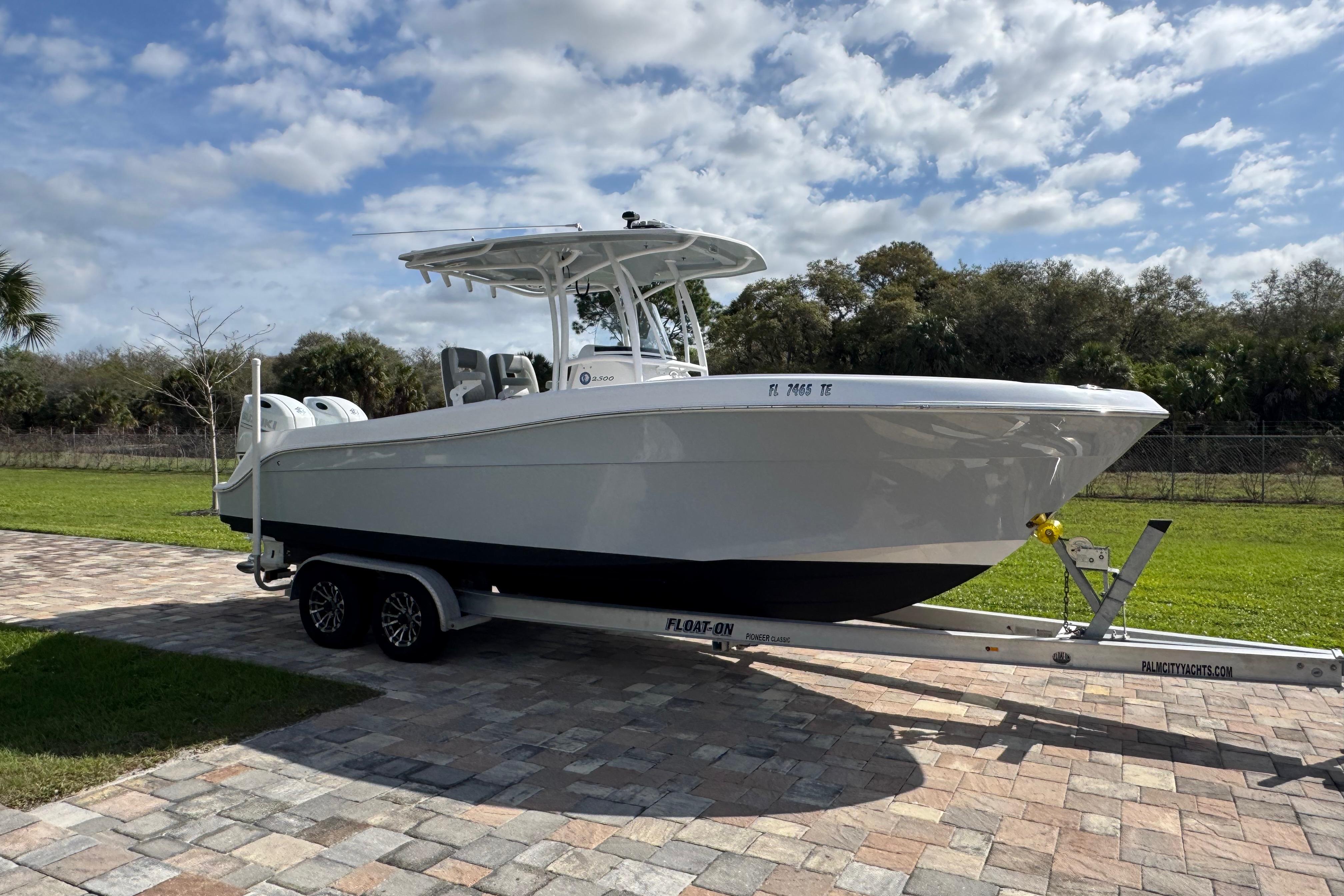 2022 Aquasport 2500 Center Console boat on trailer, parked on paved driveway.