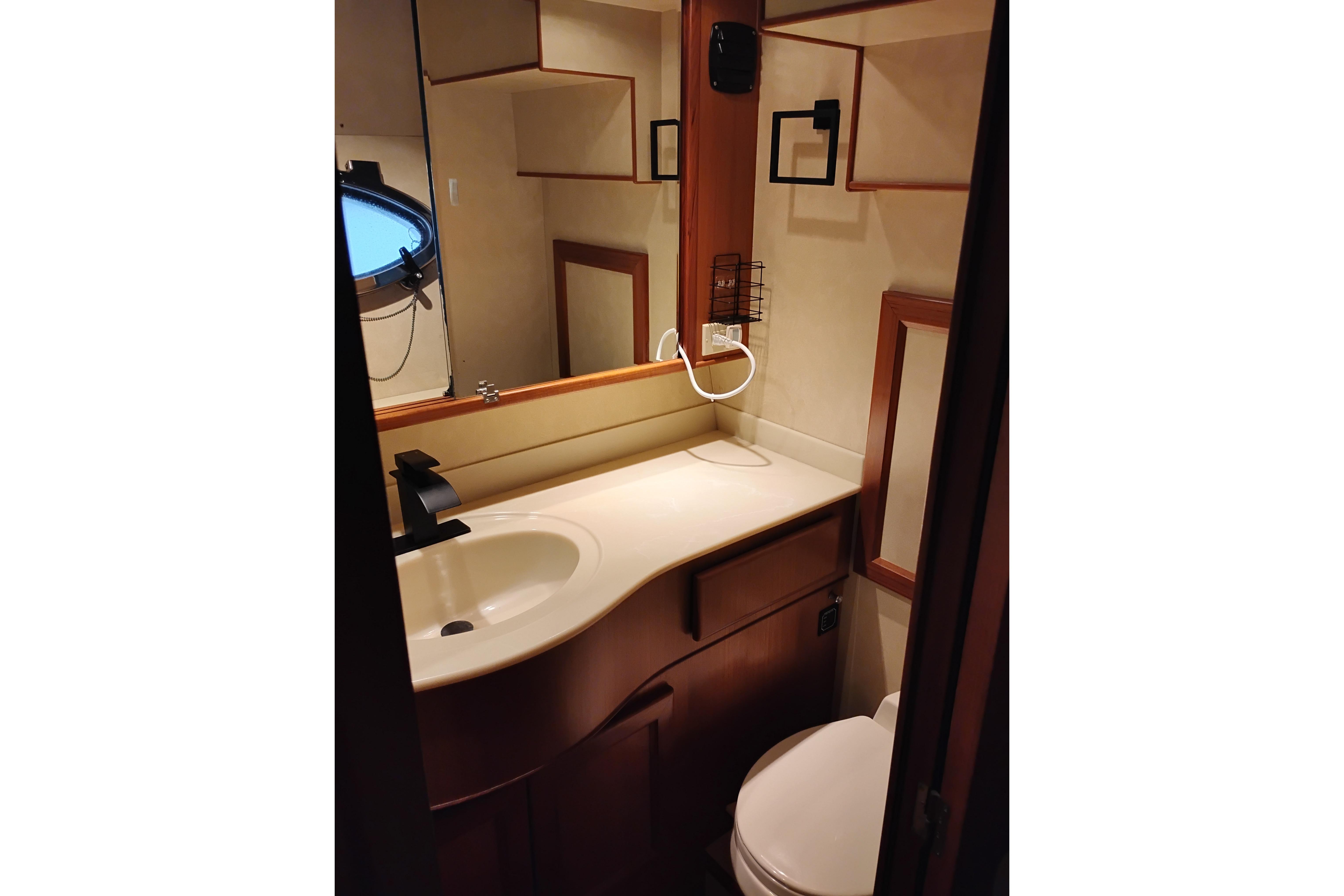 Bathroom interior of a 1997 Symbol 50 Pilothouse yacht, featuring sink and mirror.