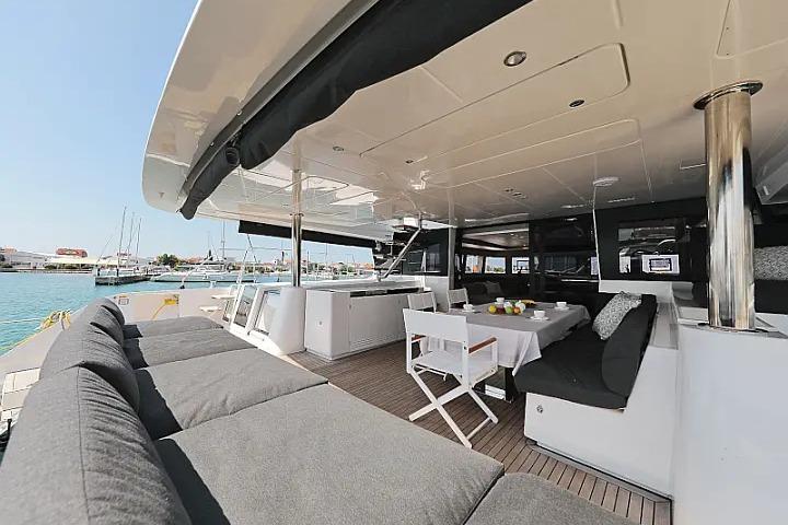 Luxurious 2018 Lagoon 620 Esense yacht with spacious outdoor seating and dining area.
