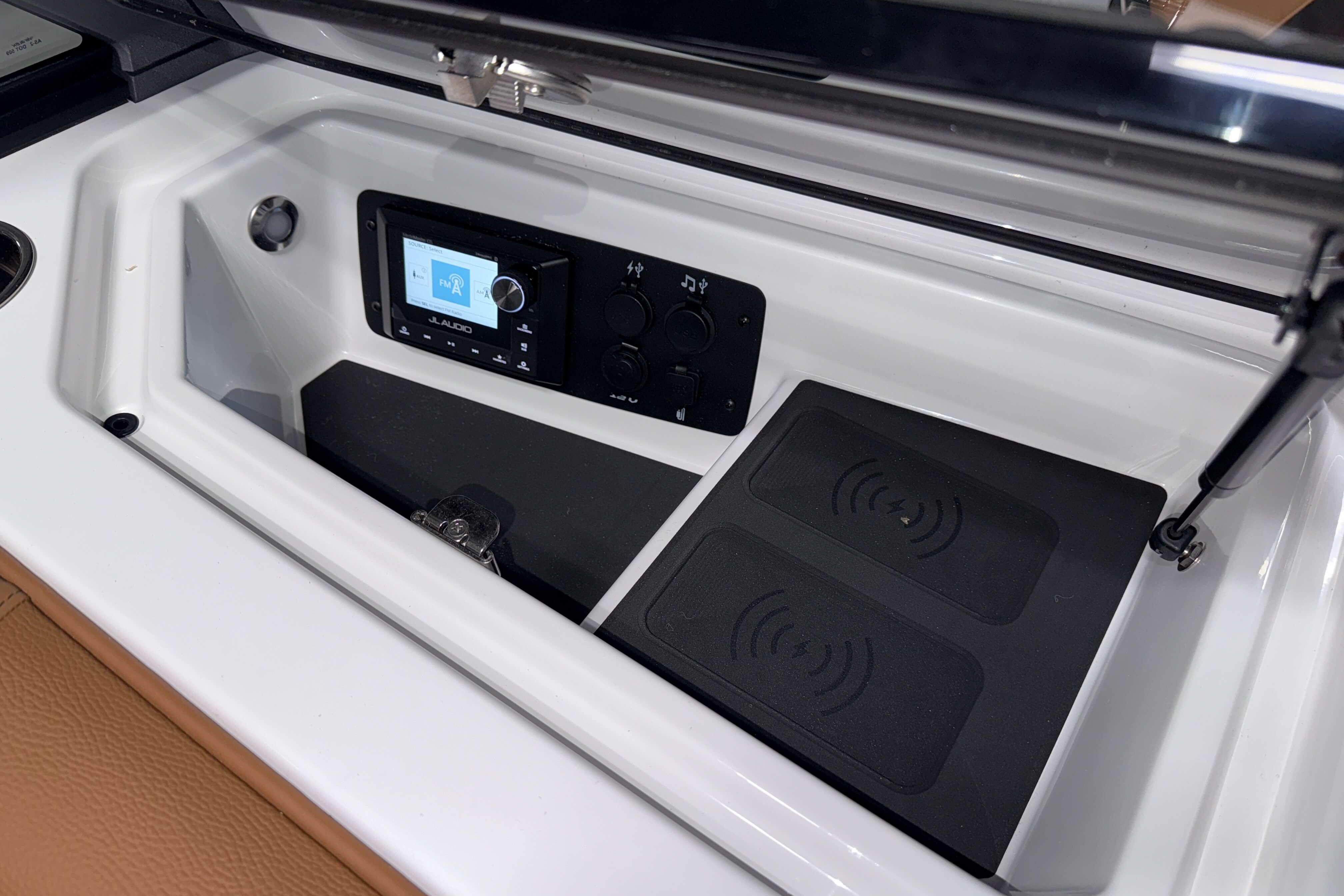 2026 Nautique Super Air Nautique S23 dashboard with JL Audio system and wireless charging pads.