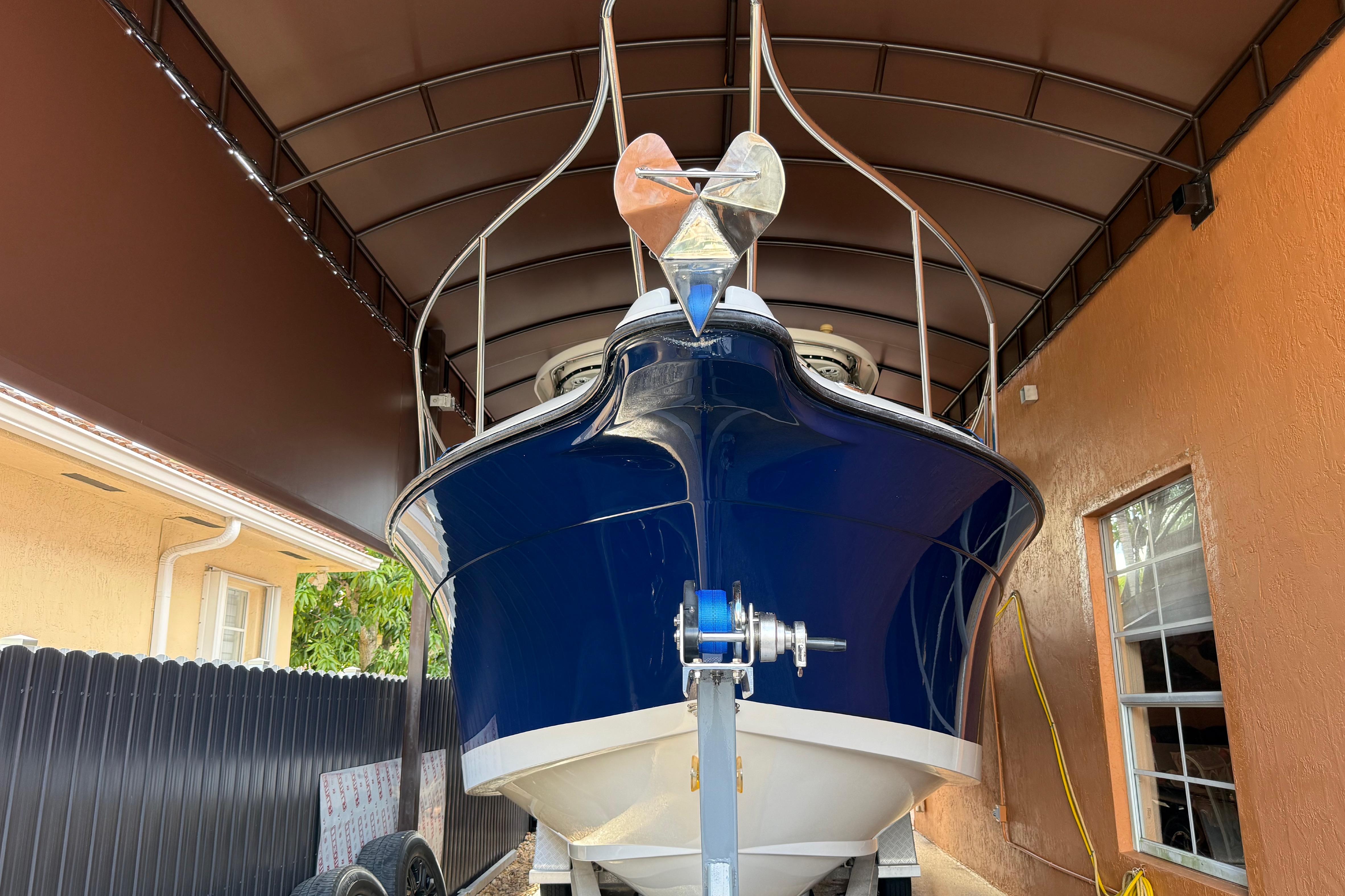 2005 Seaswirl Striper 290 boat under a covered shelter, front view.