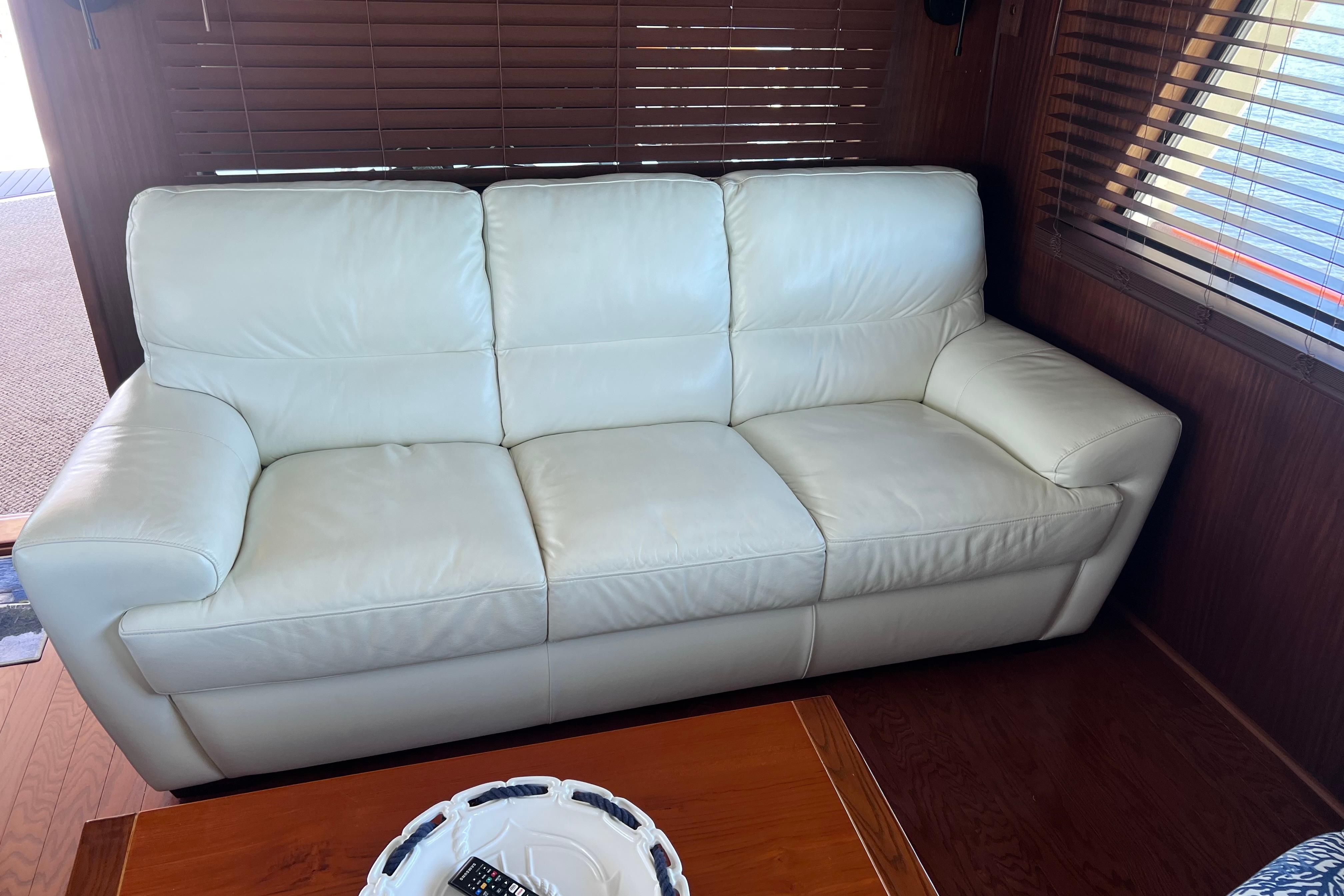Luxurious white leather sofa in 1987 Hatteras 70 Cockpit Motor Yacht interior.