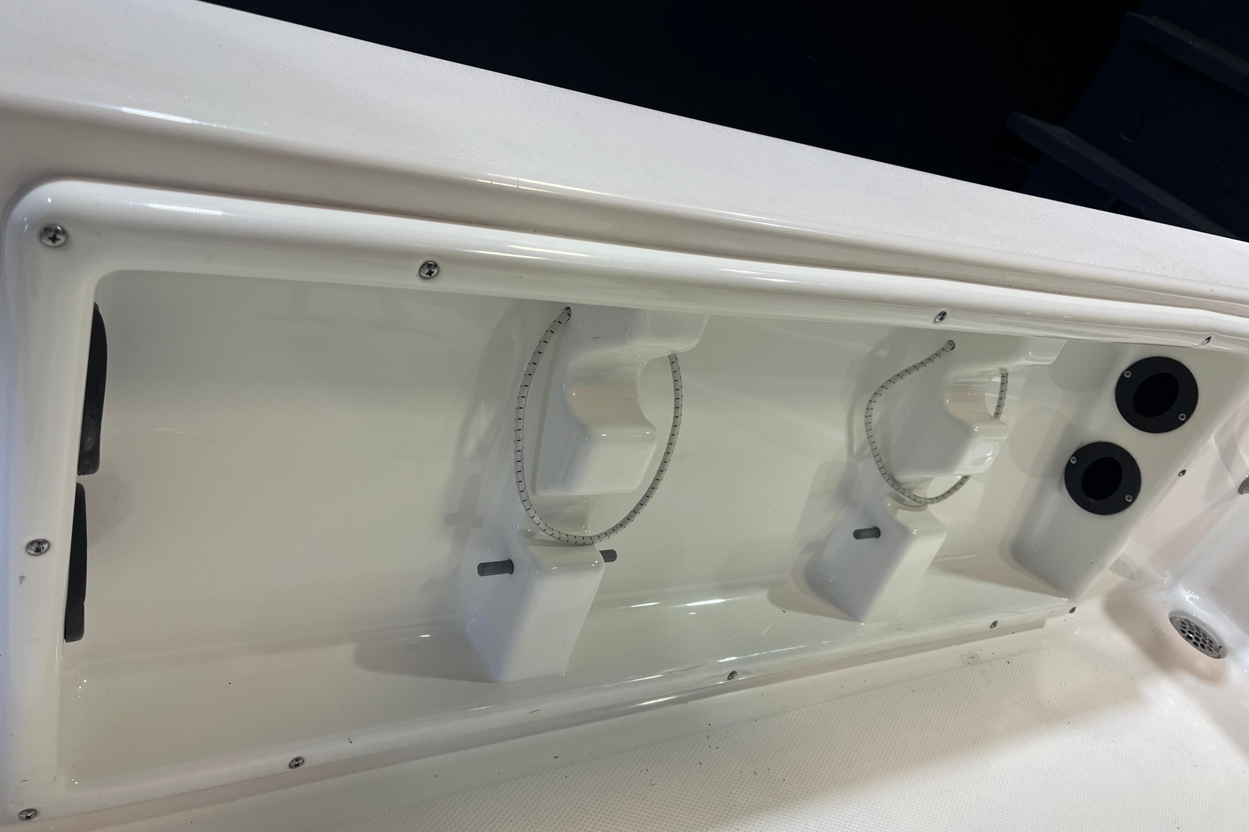 2023 NauticStar 227 XTS boat interior detail with rod holders and storage compartments.