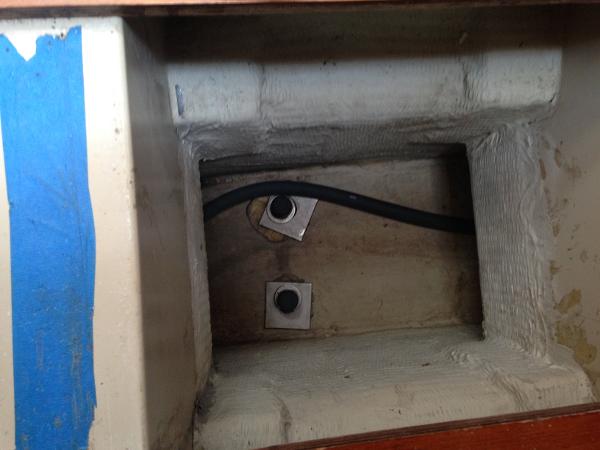 An interior section of a boat with cables and blue covering.