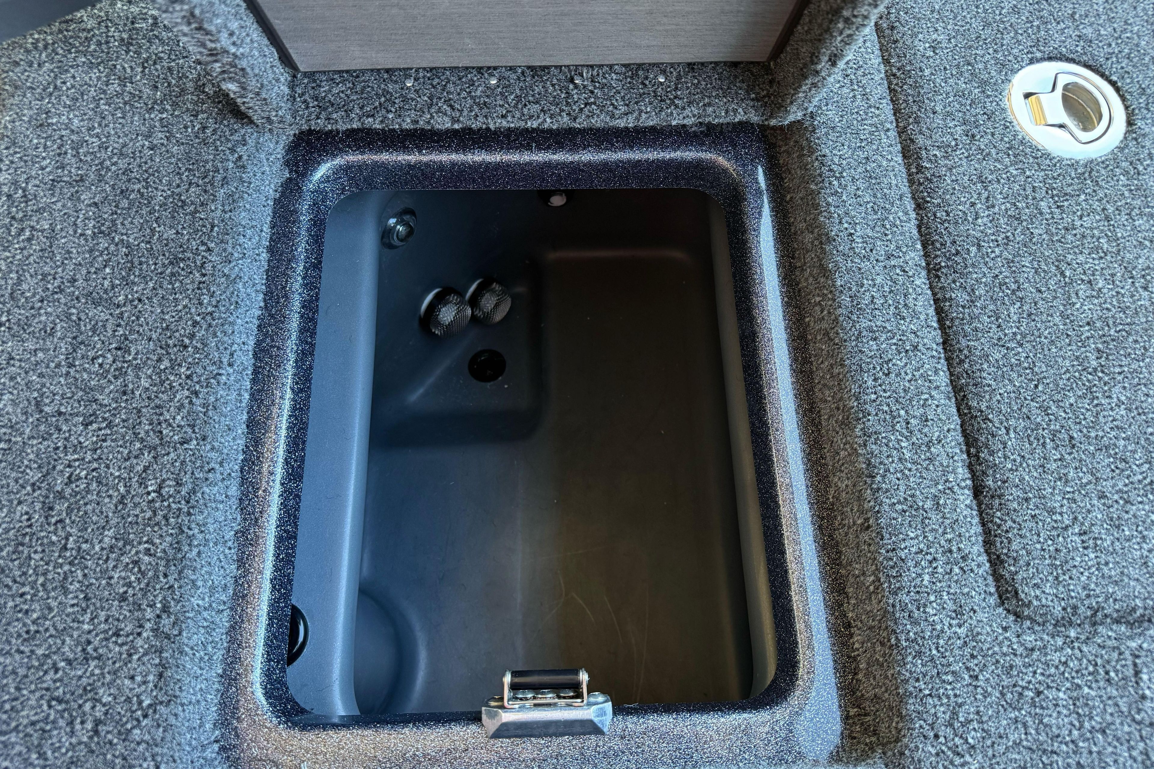 Storage compartment of 2026 Triton 21XP Patriot boat, featuring carpeted interior.