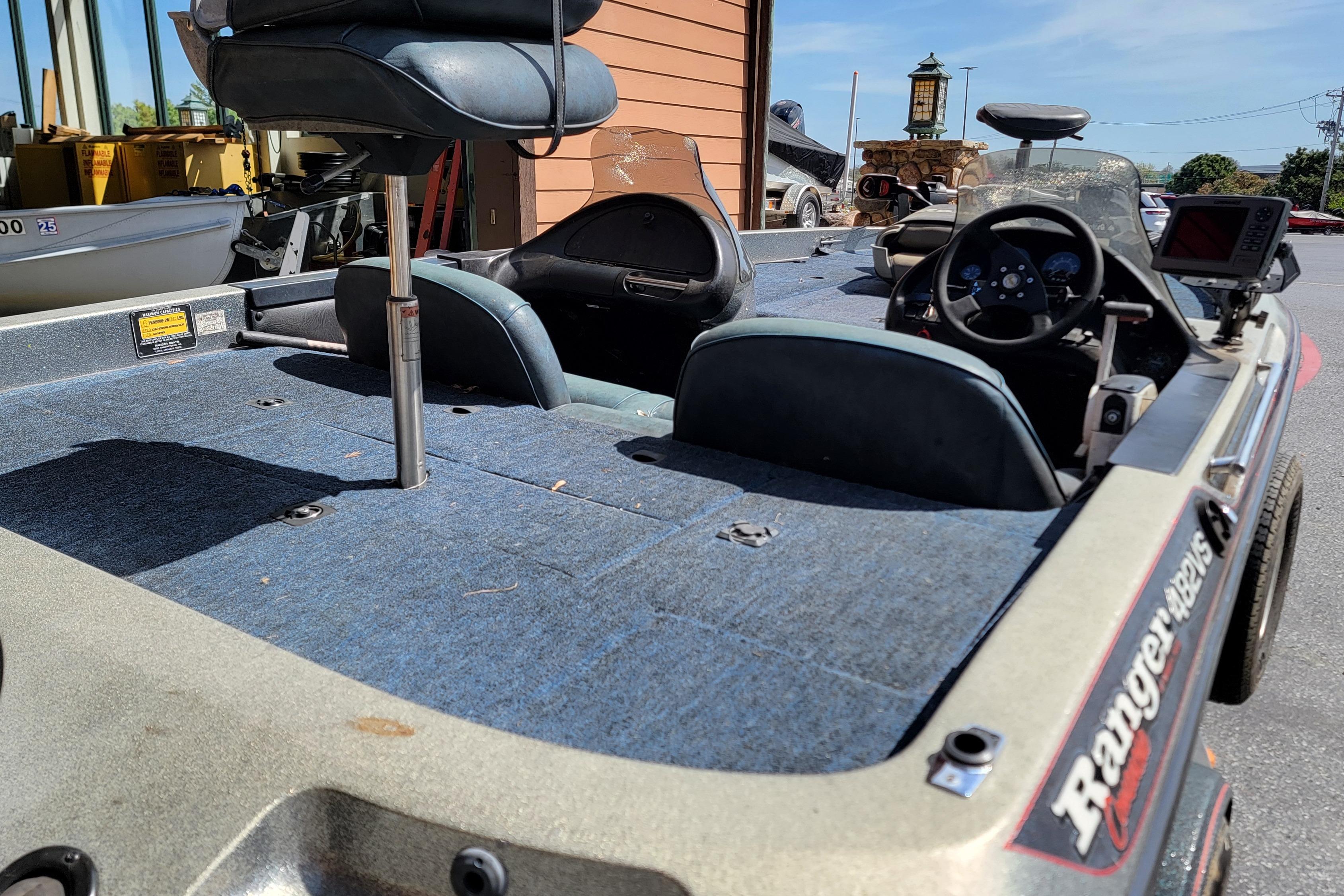 1995 Ranger boat interior with blue carpet and steering console, parked outdoors.