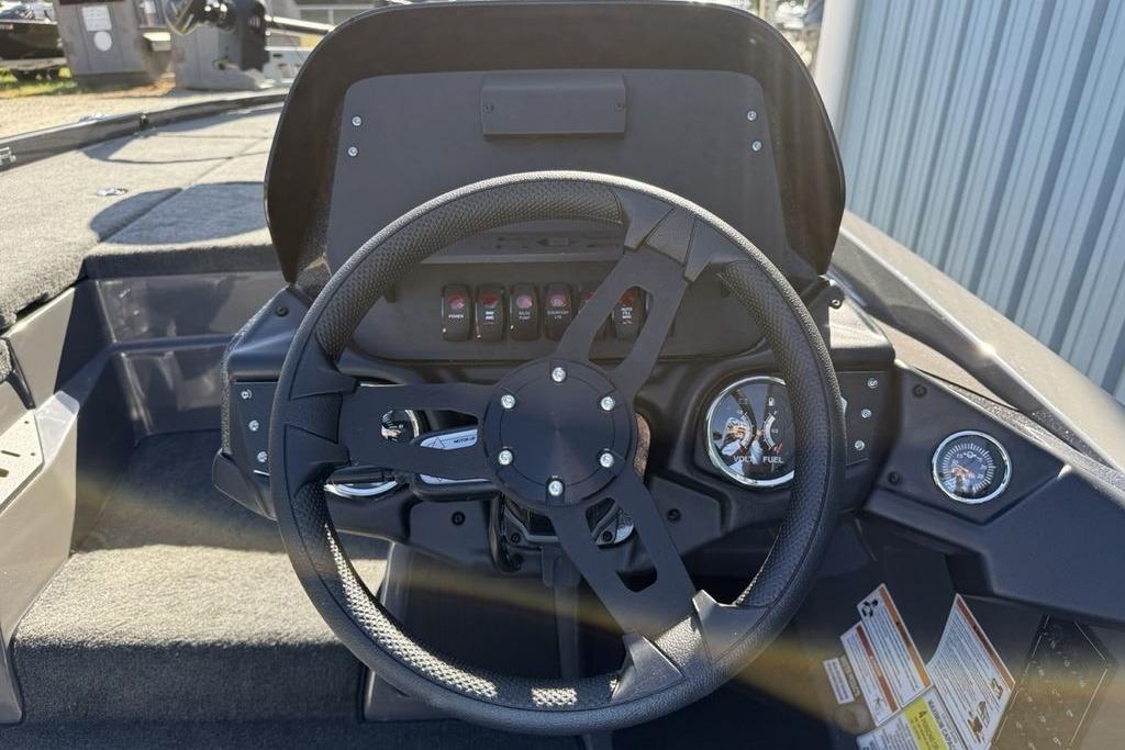 2026 Skeeter ZX150 boat dashboard with steering wheel and gauges in sunlight.