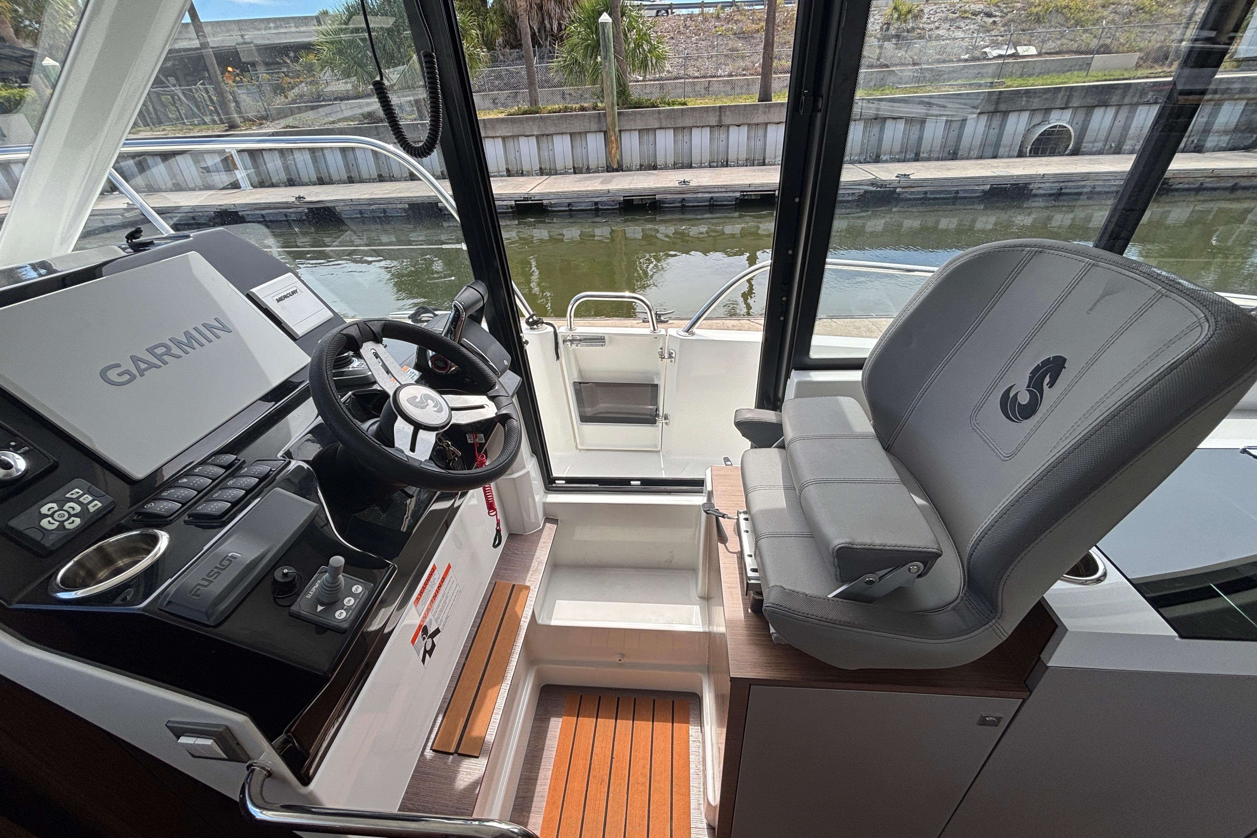 2024 Beneteau Antares 11 helm with Garmin navigation, luxurious seating, and modern controls.