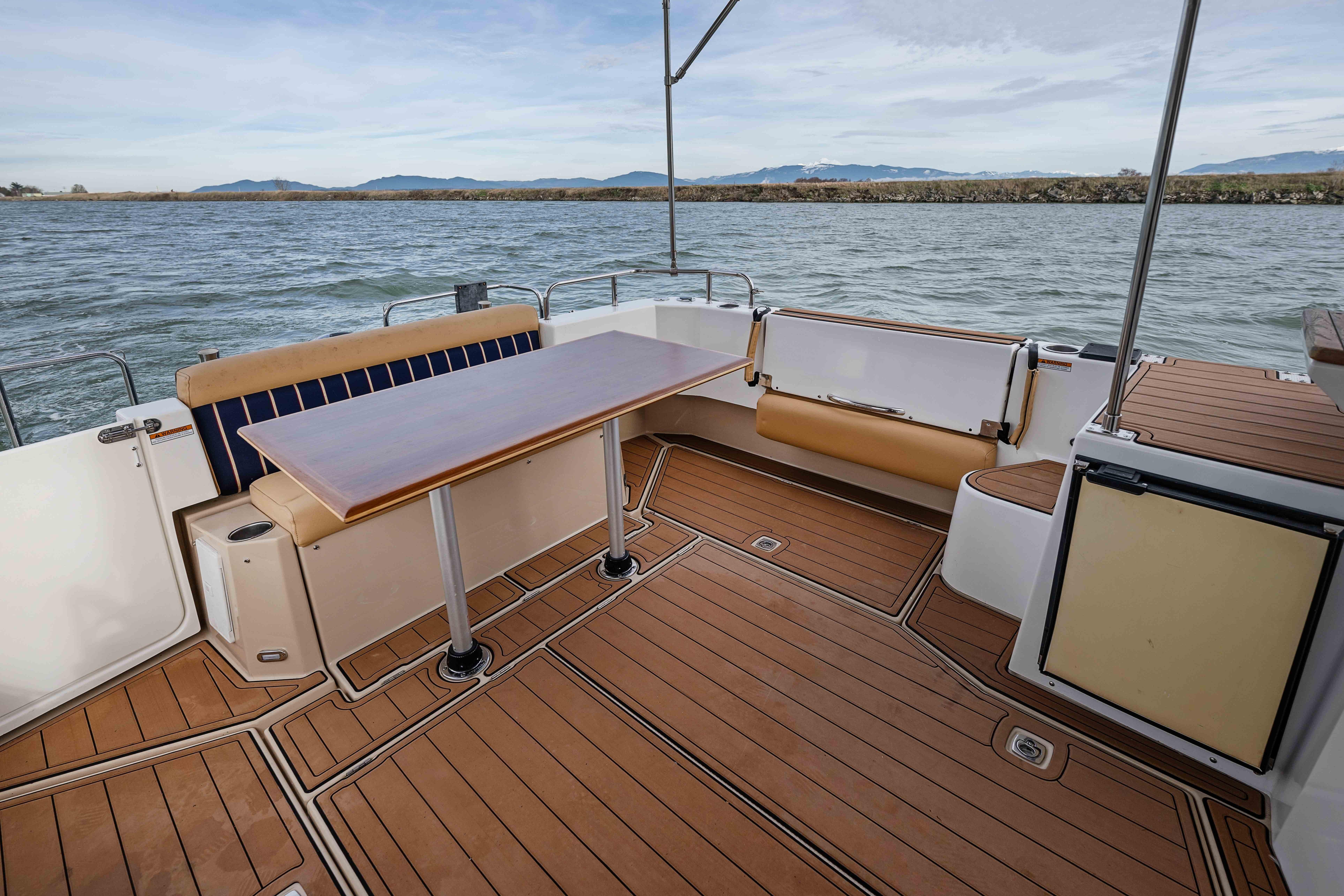 2014 Ranger Tug R-31 CB boat deck with seating and table, overlooking water.
