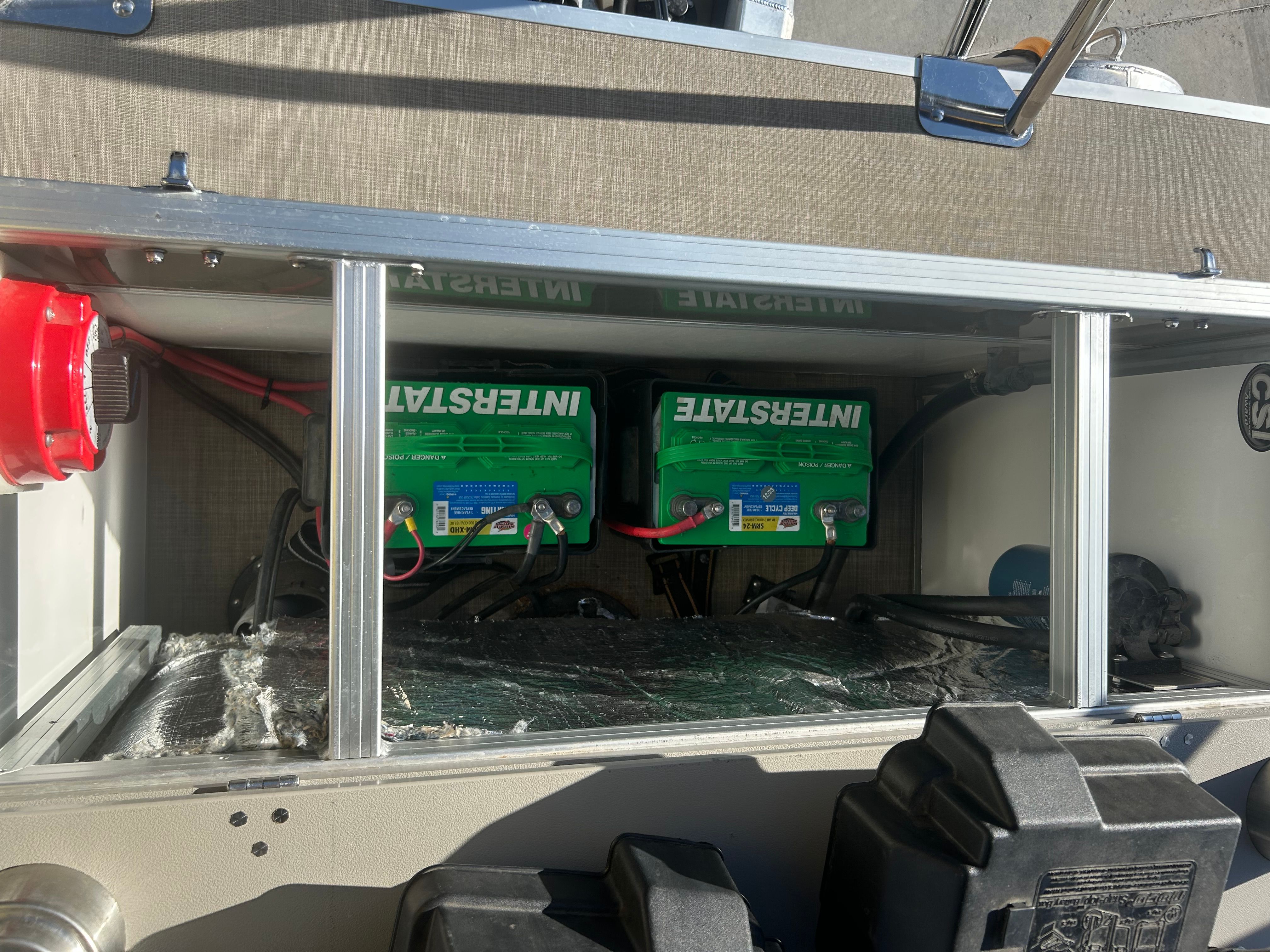 The image shows the battery compartment of a 2018 Berkshire 24RFX CTS boat with two green batteries.