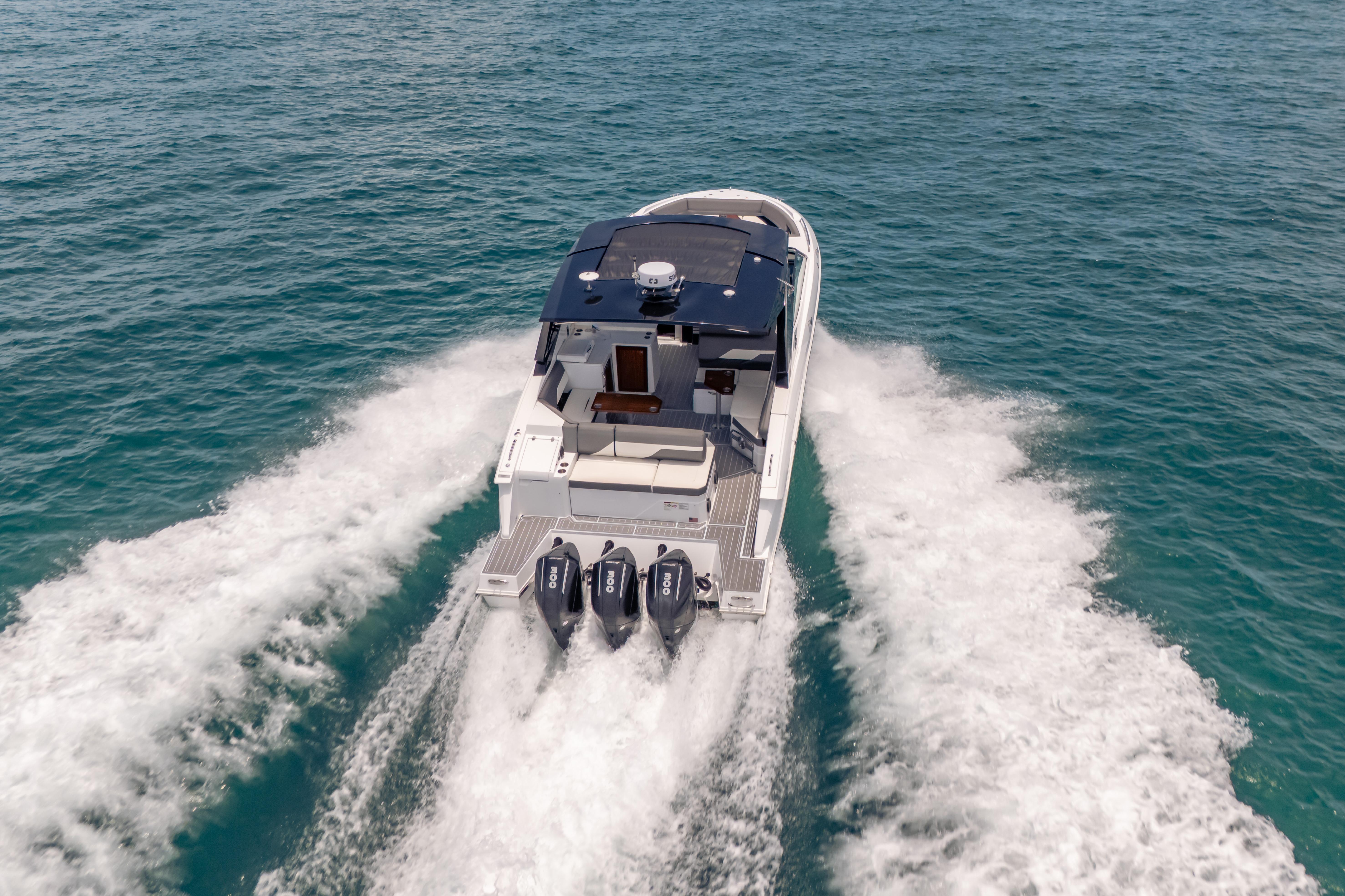 2021 Cruisers Yachts 38 GLS speeding on open water, showcasing powerful triple engines.