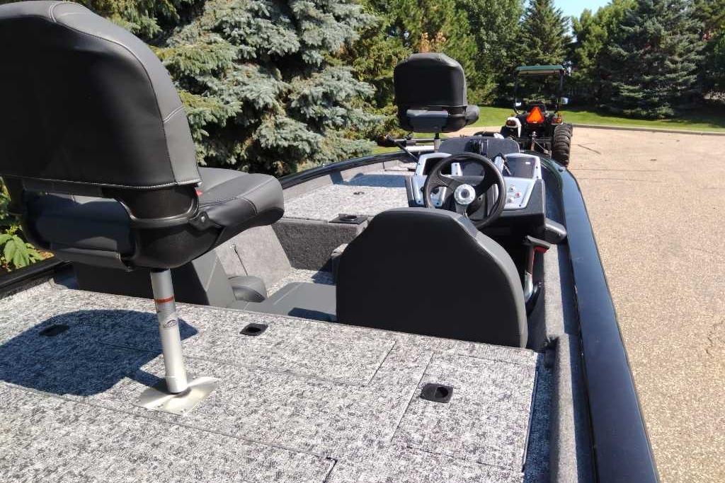 2026 Tracker Pro Team 190 boat interior with steering wheel and seating, parked outdoors.