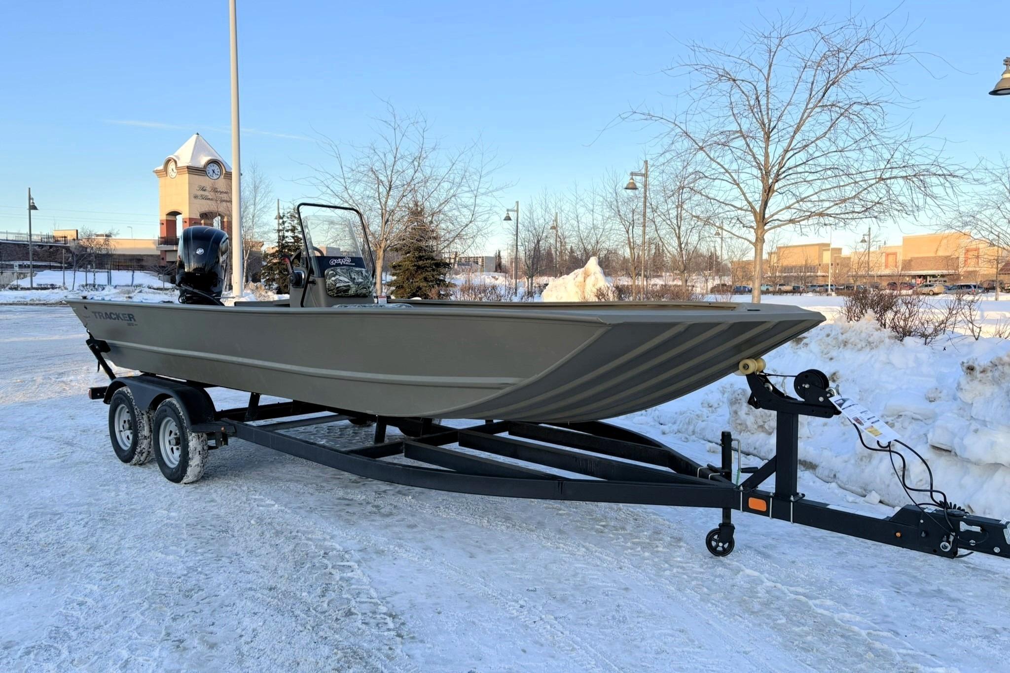 2024 Tracker Grizzly 2072 CC boat on trailer in snowy parking lot.