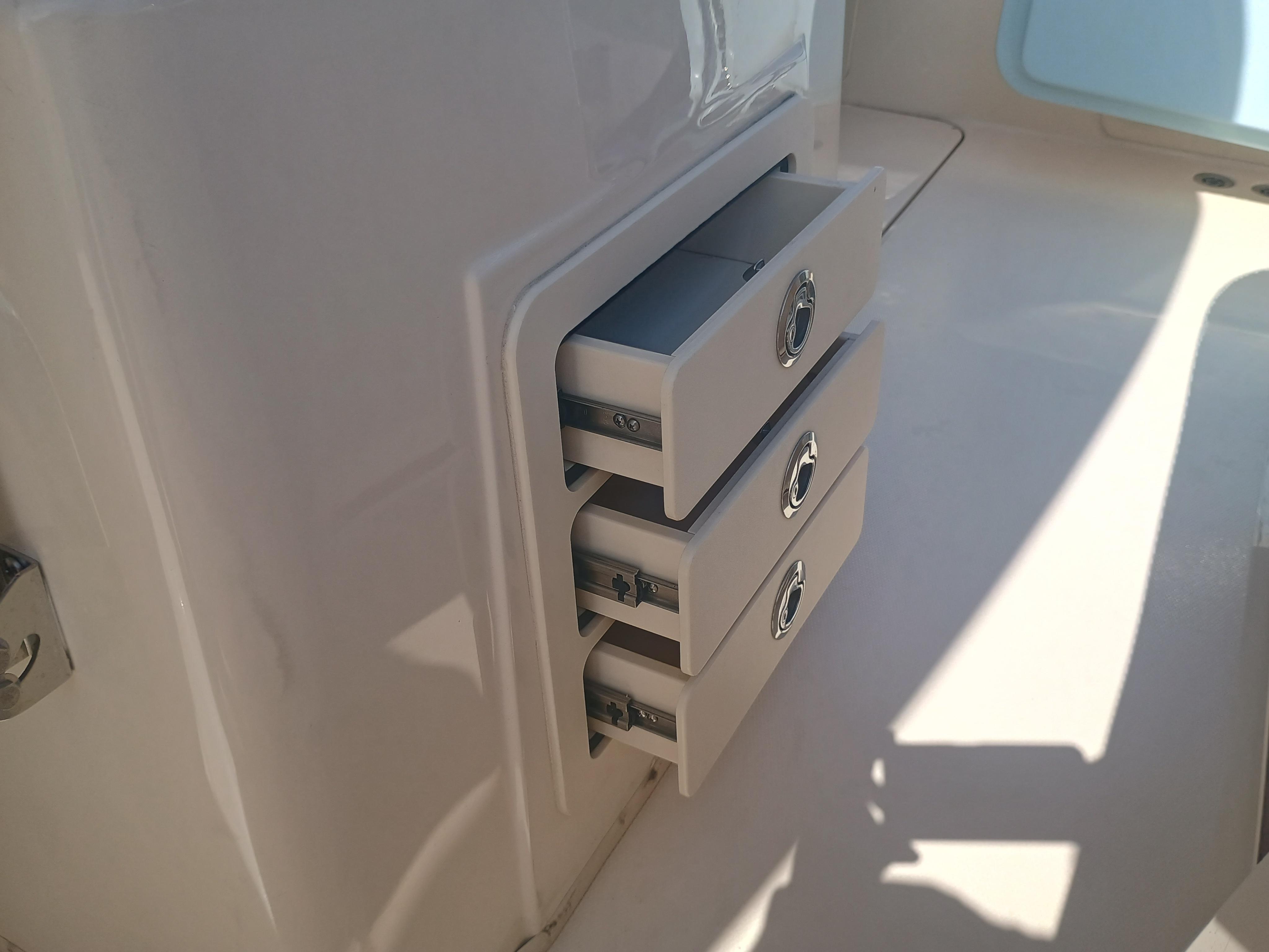 Storage drawers on a 2025 Grady-White Canyon 306 boat, partially open.