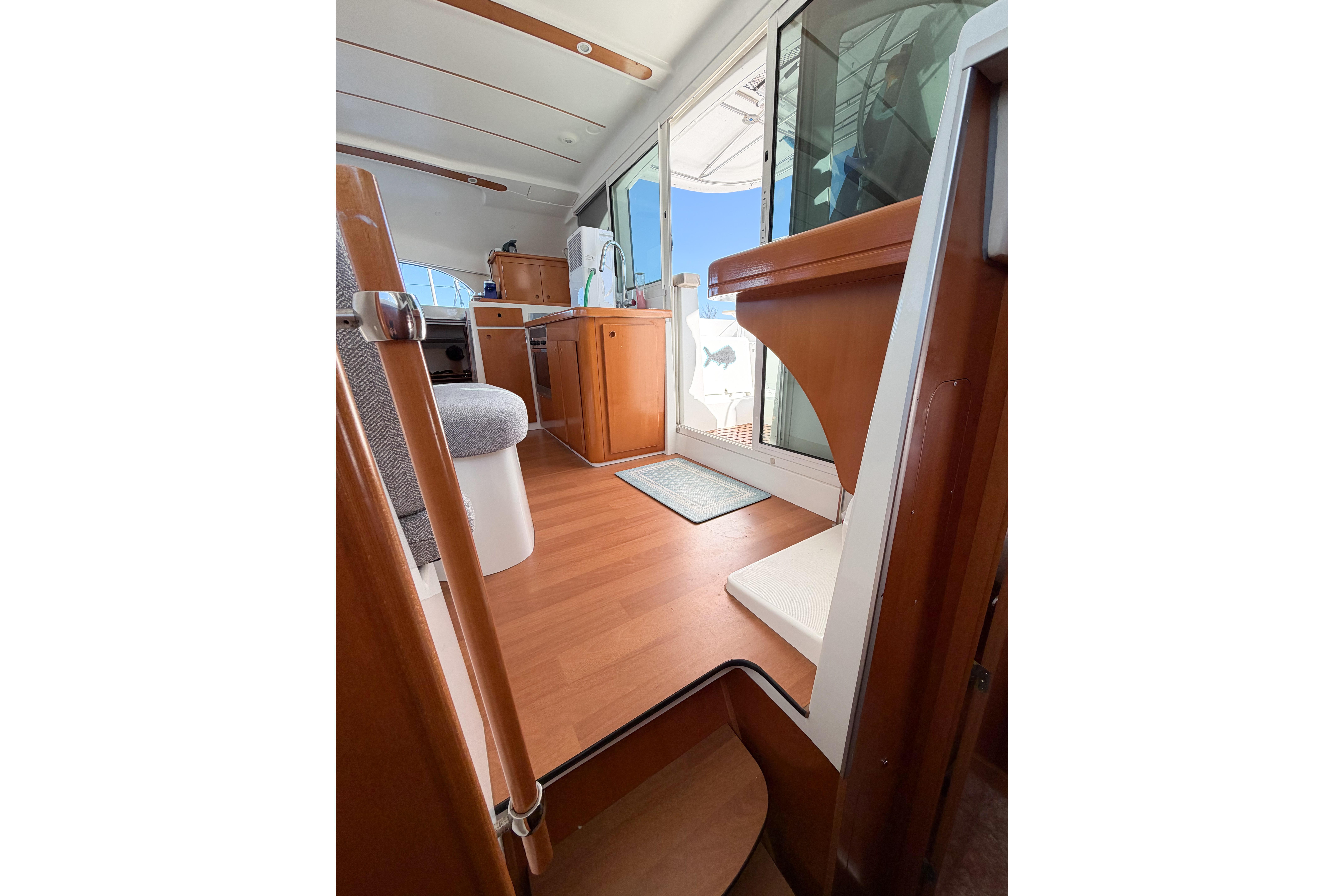 Interior view of 2005 Lagoon 380 S2 catamaran, featuring wooden flooring and modern furnishings.