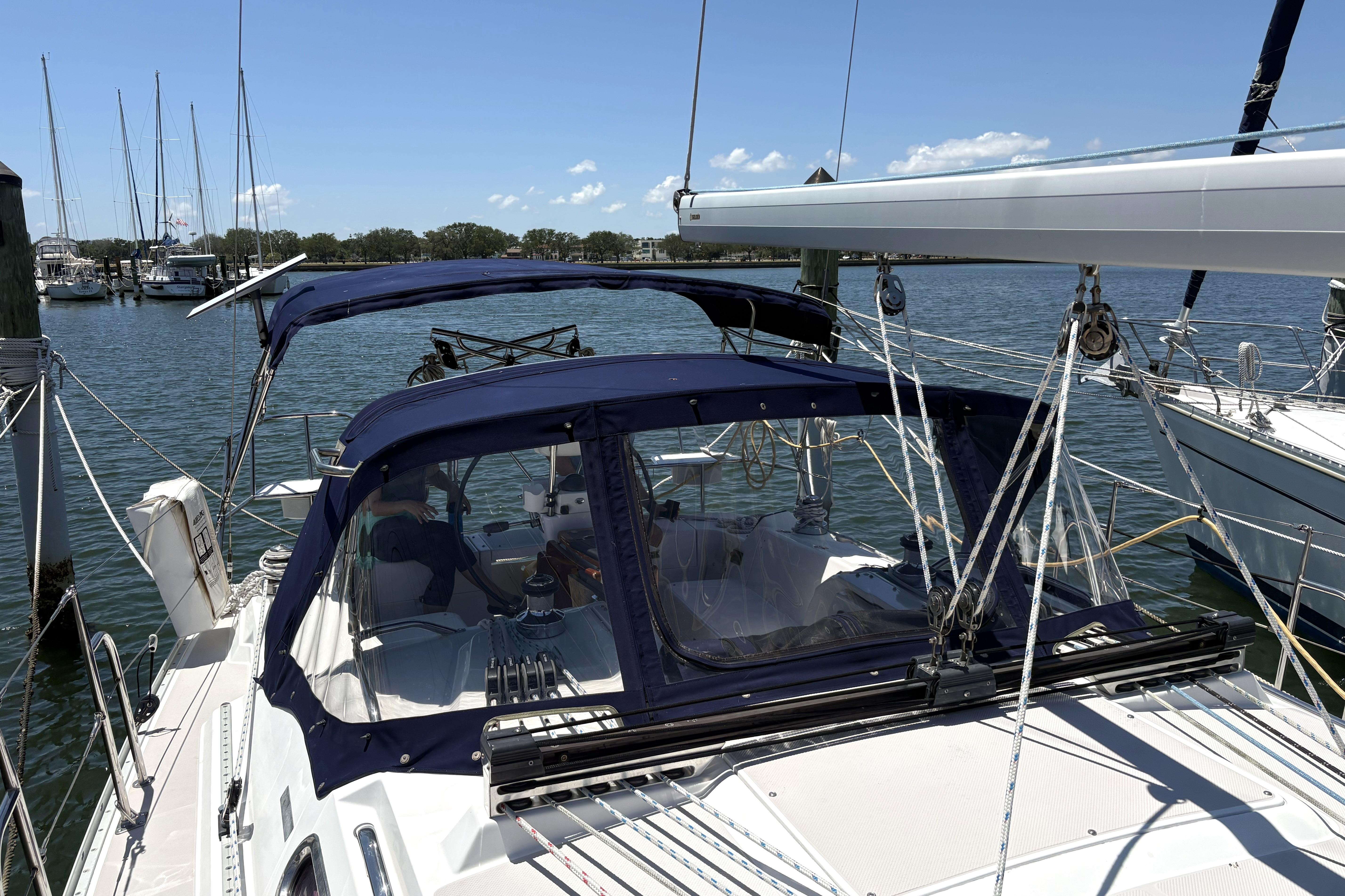 Sailboat Catalina 355, 2011 model, docked at marina with blue canopy and clear skies.