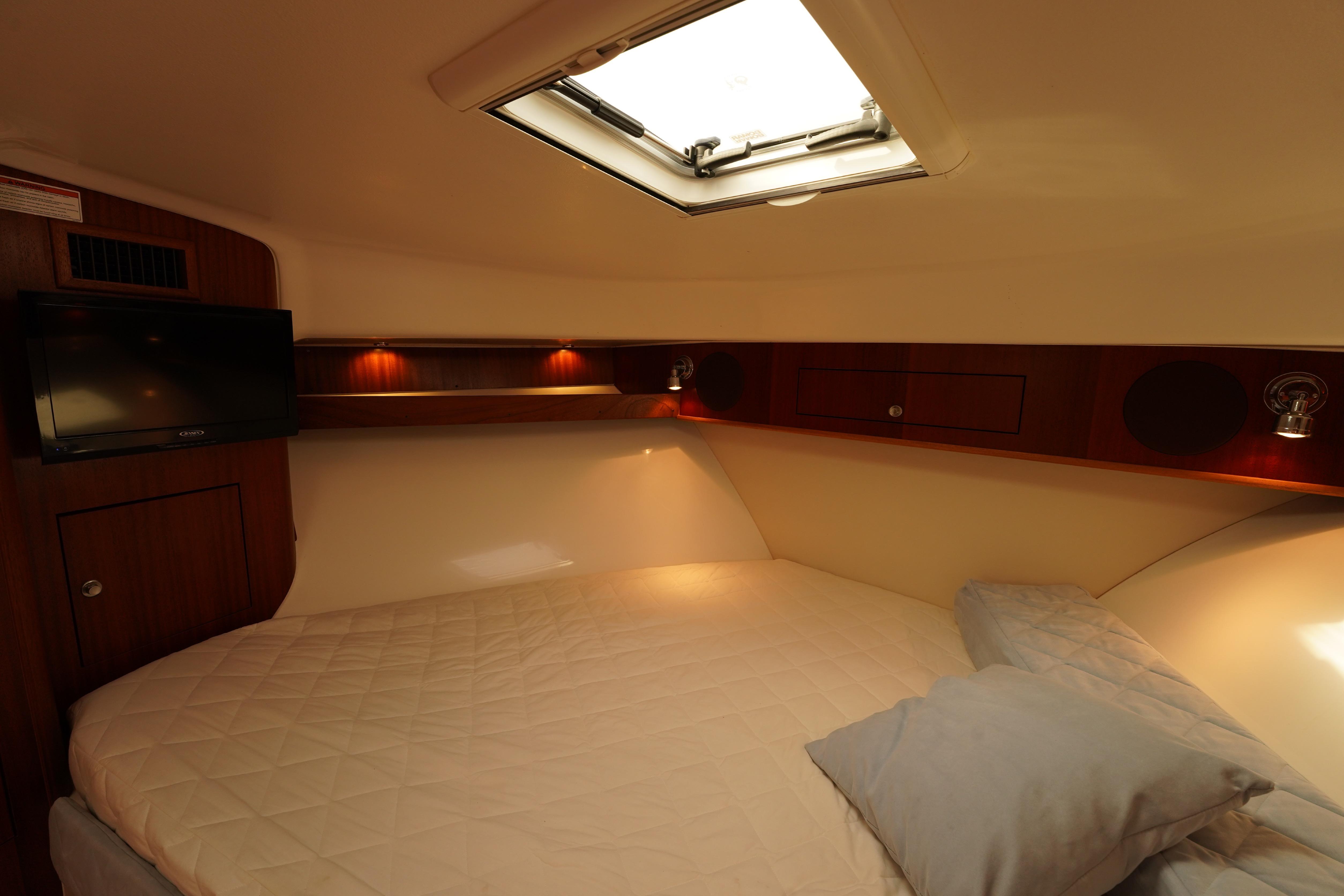 2015 Pursuit OS 385 Offshore cabin interior with bed, TV, and skylight.
