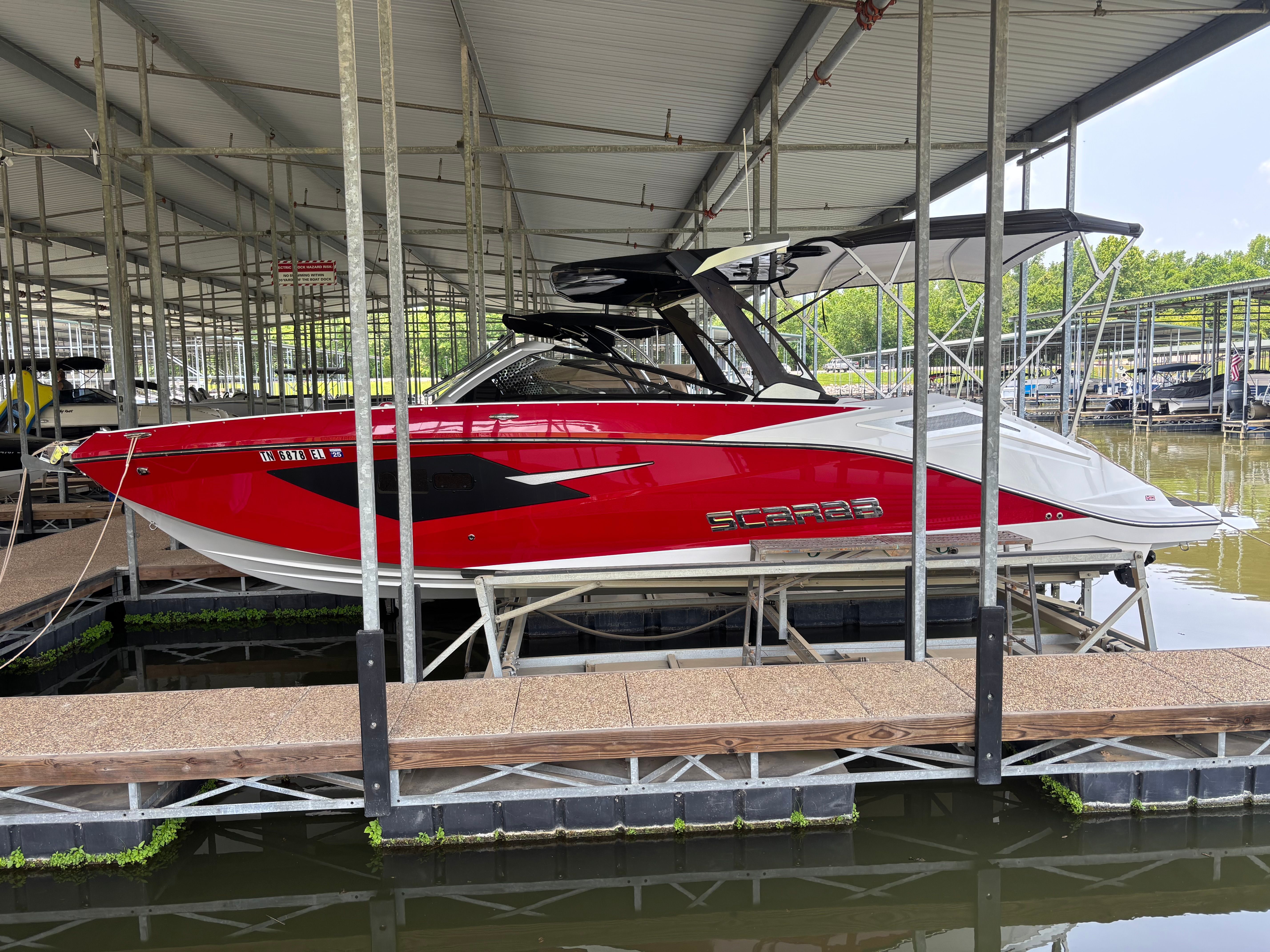 Red 2021 Scarab 285 ID boat docked in marina.
